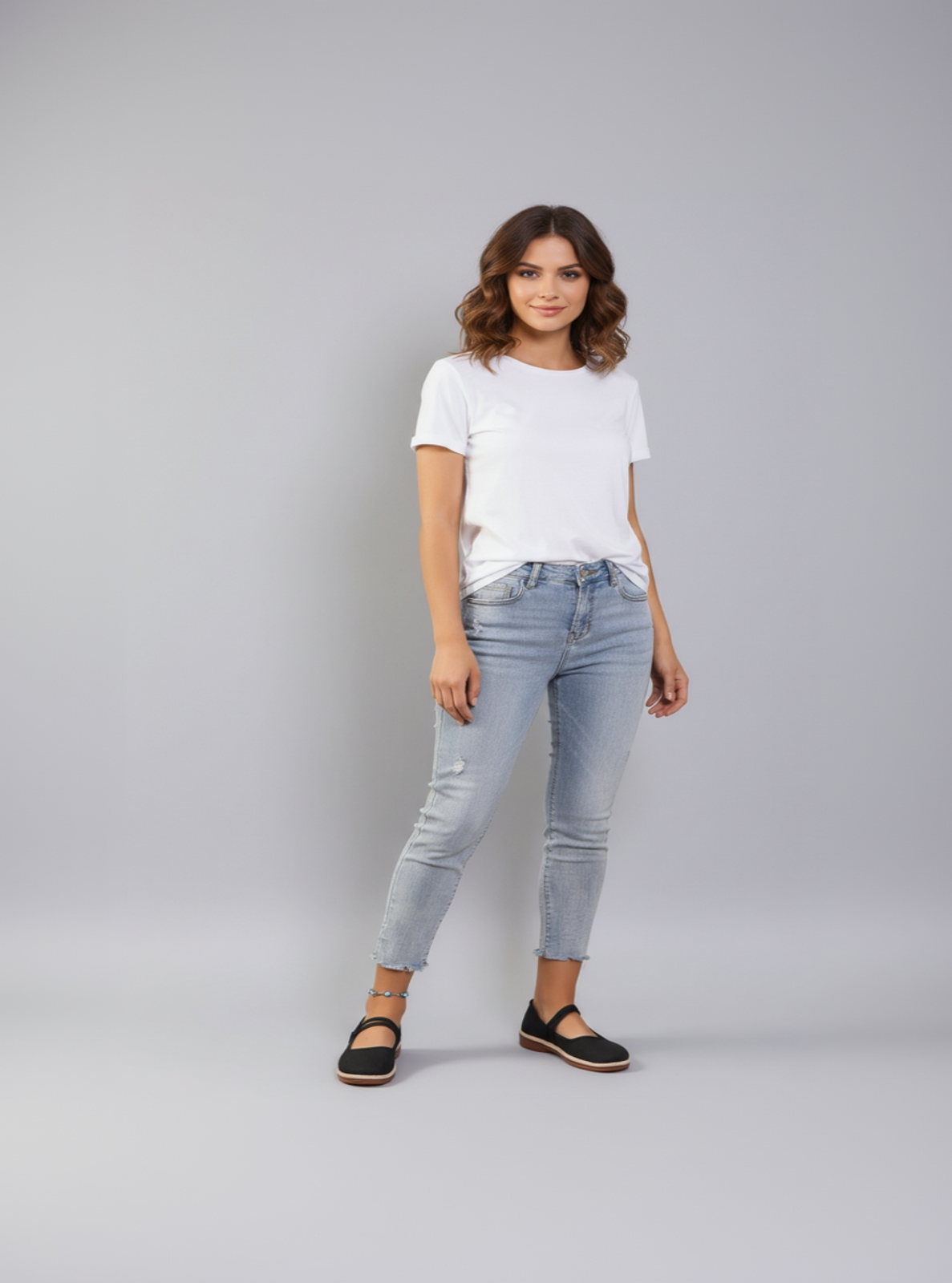Woman wearing a white t-shirt and light blue jeans on a gray background