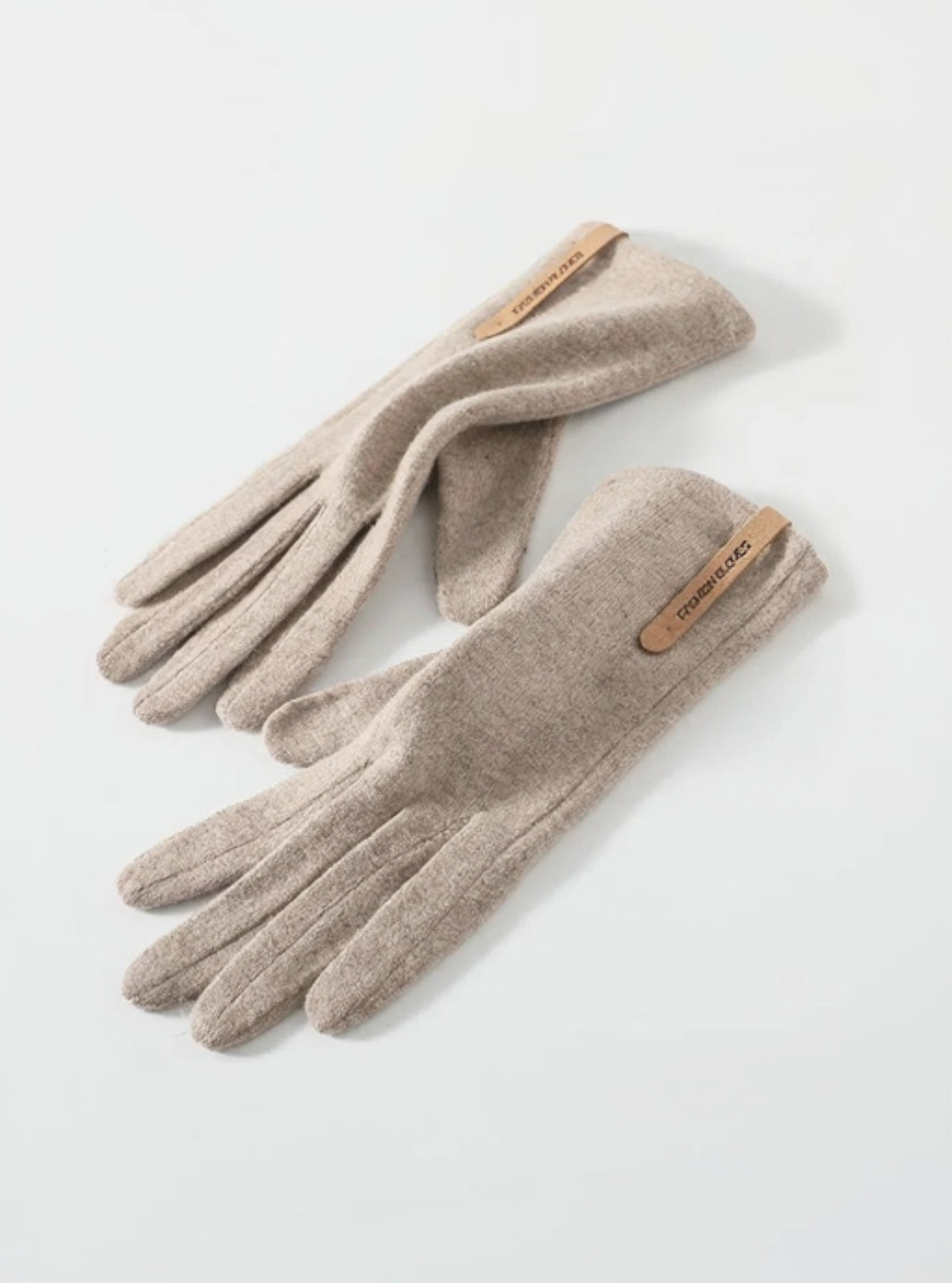 Pair of beige gloves with brand logo on a light gray background