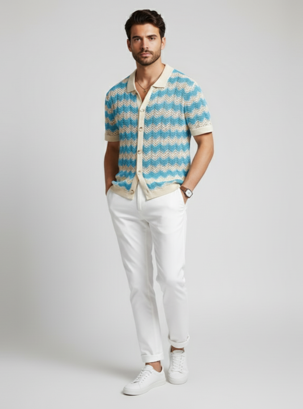 Man wearing a patterned shirt and white pants on a plain background