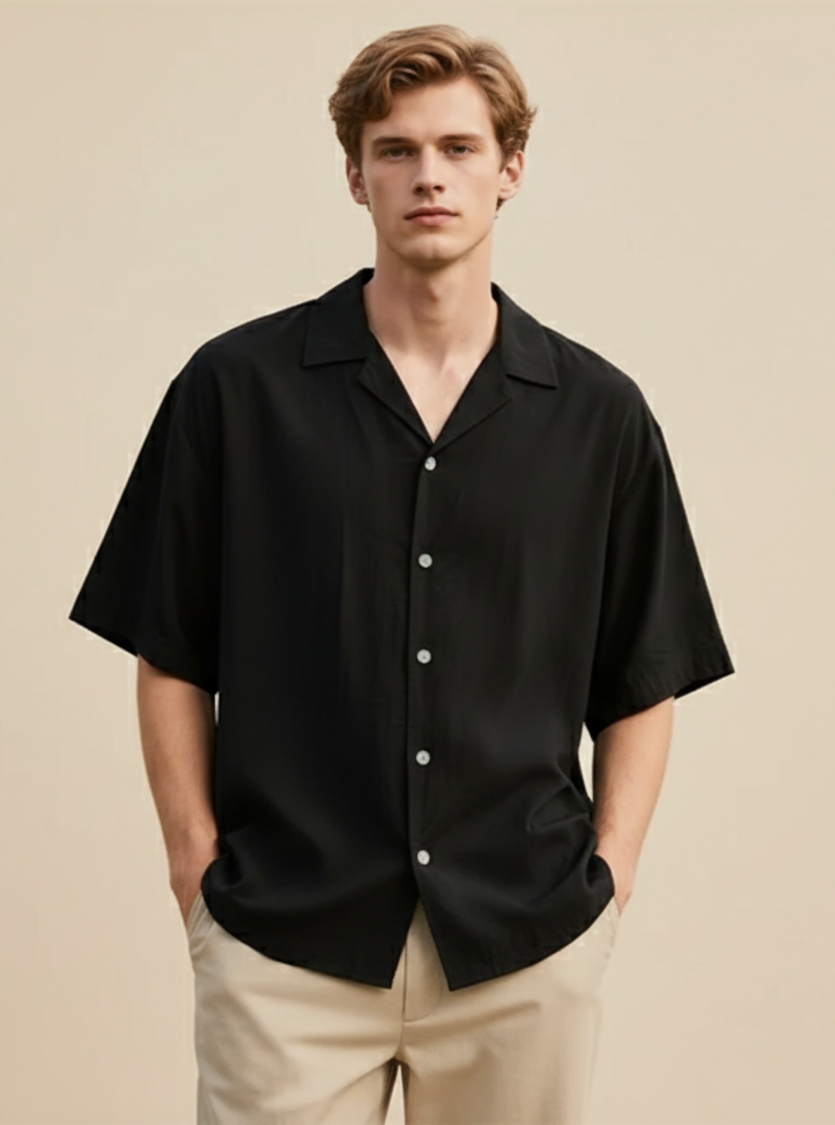 Man wearing a black short-sleeve shirt on a beige background