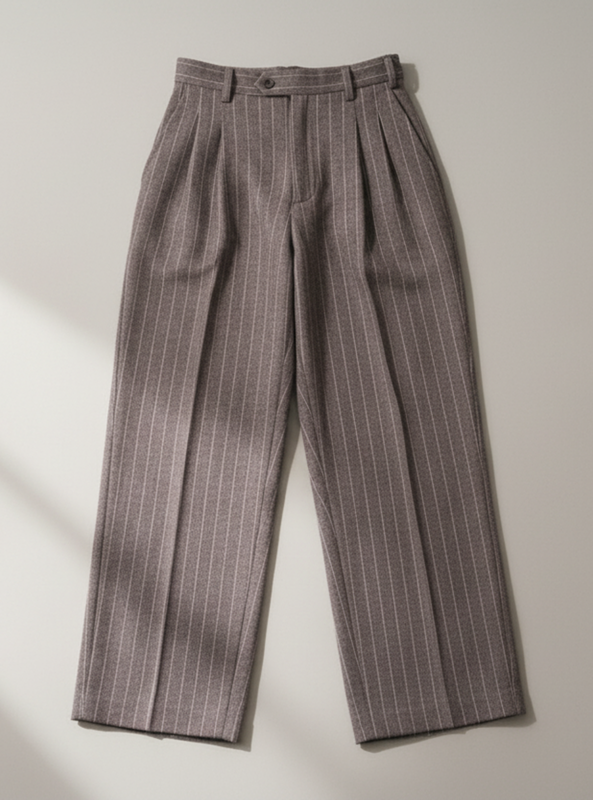 Pair of brown pinstripe pants on a light gray background