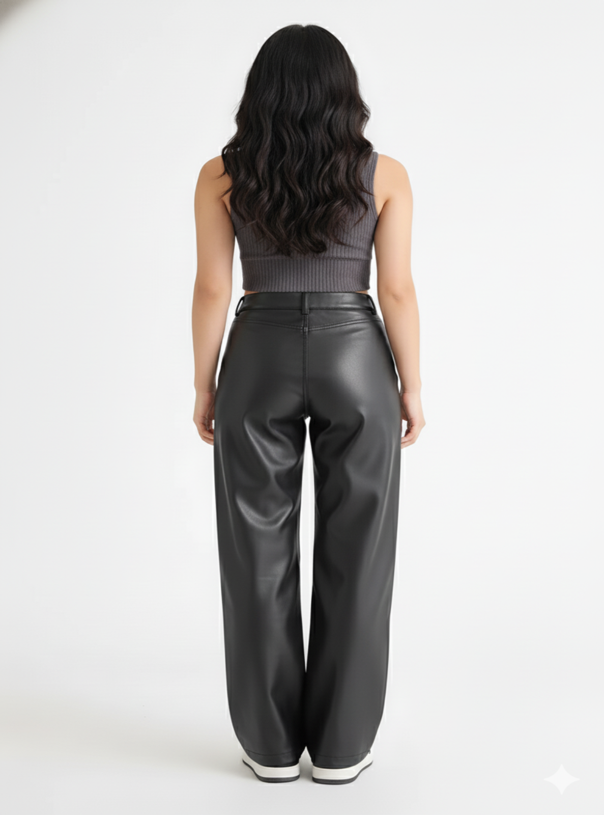 Person wearing black leather pants on a white background