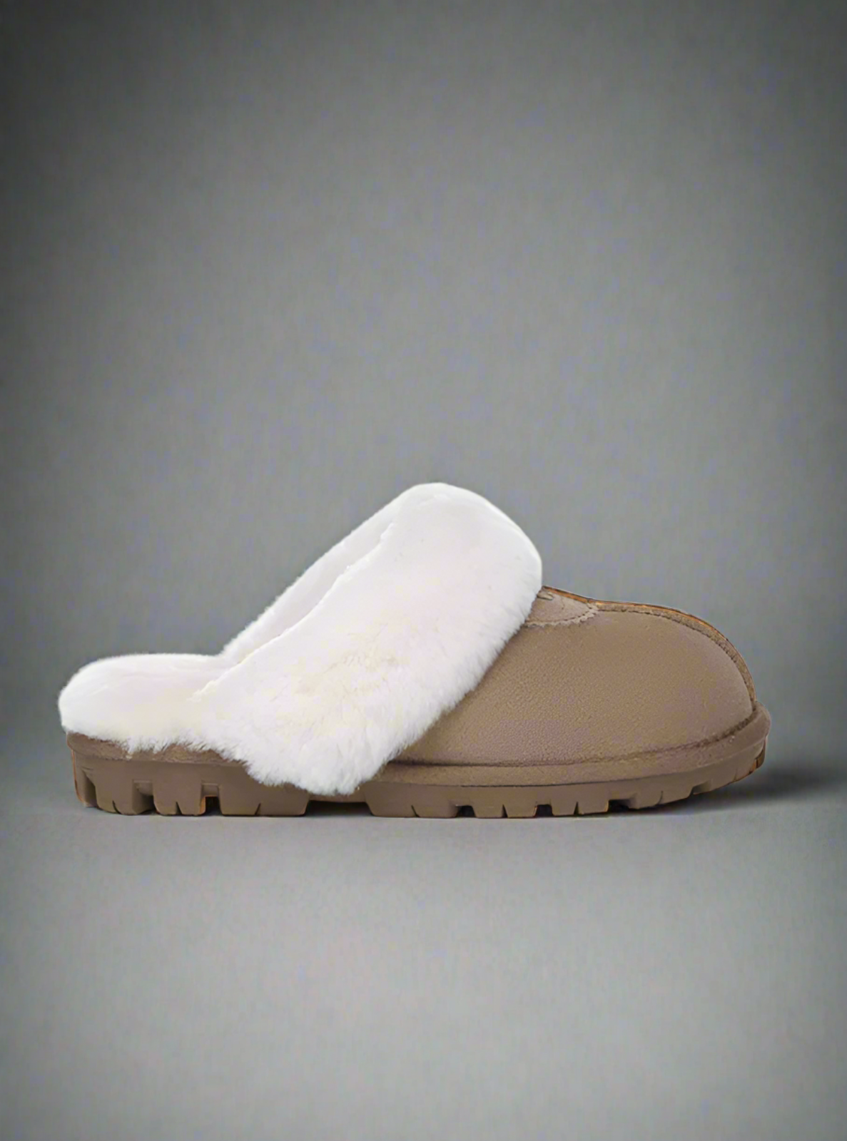 Beige slipper with white fur lining on a gray background