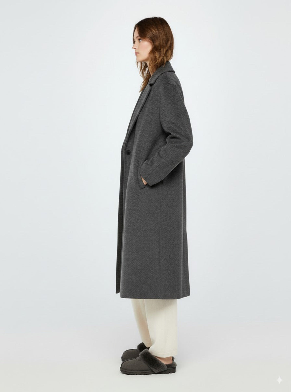 Person wearing a gray coat on a white background