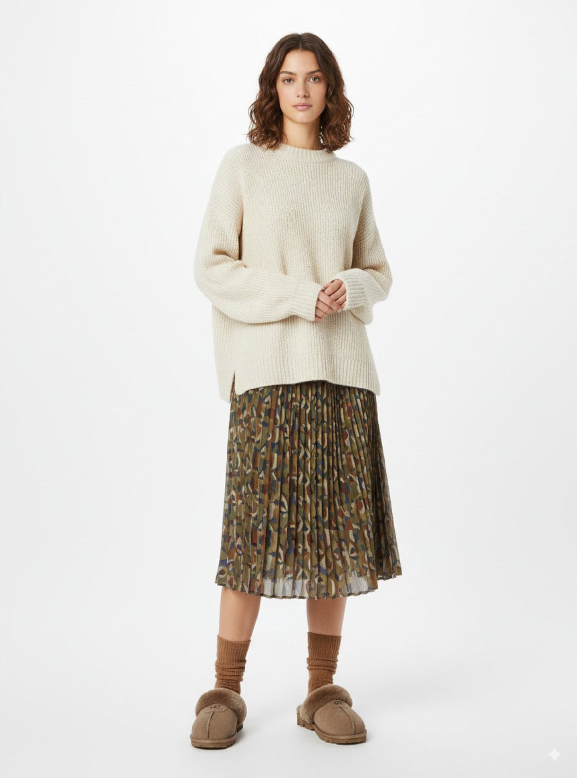 Woman wearing a cream sweater and patterned skirt on a white background