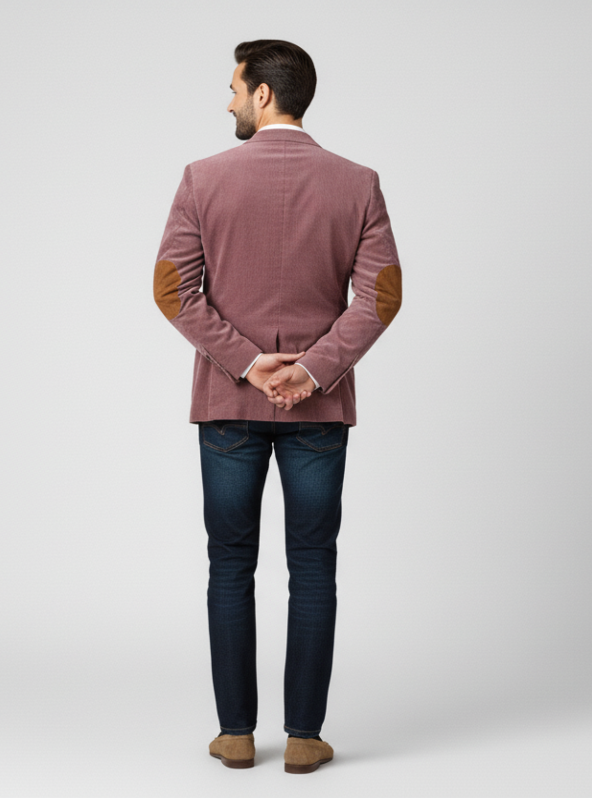 Man wearing a maroon blazer and dark jeans on a white background
