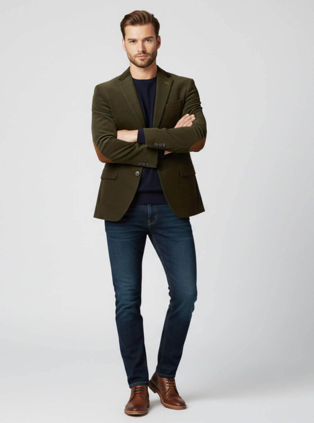 Man wearing a green blazer, blue jeans, and brown shoes on a white background