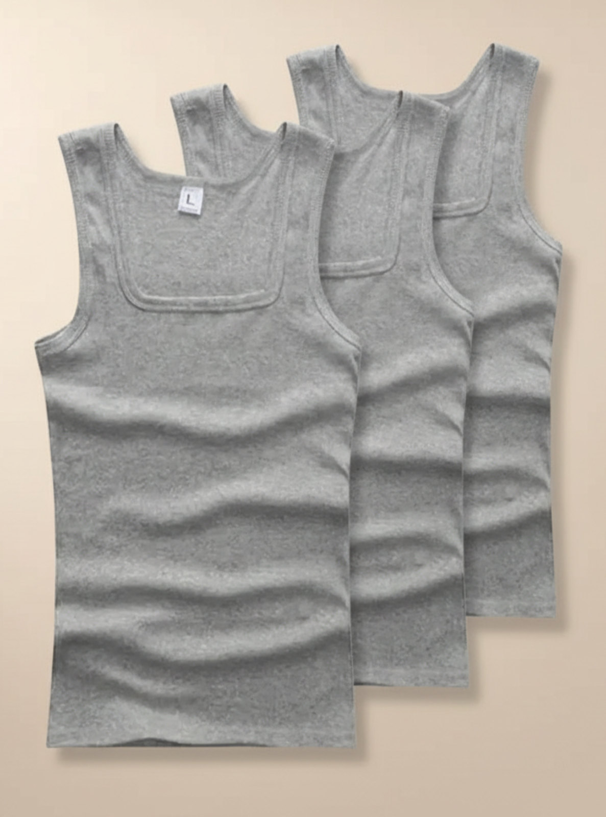 Three gray tank tops stacked on a beige background