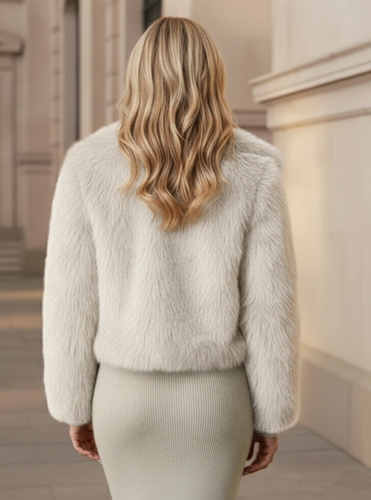 Person wearing a light gray fluffy jacket in an outdoor setting