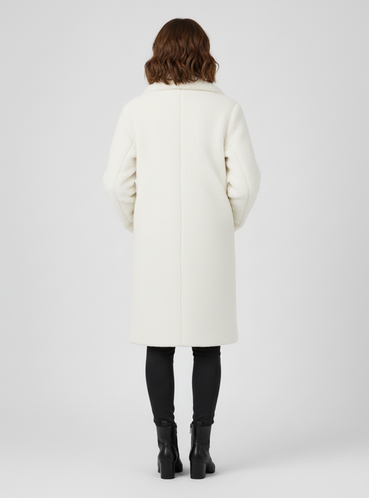 Person wearing a white coat on a plain background