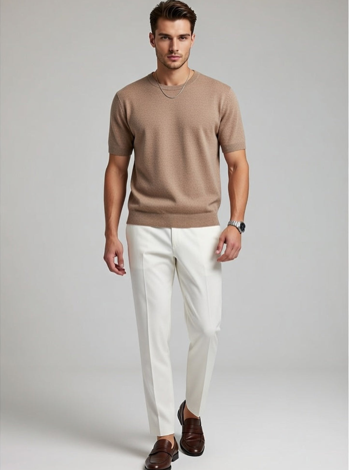 Man wearing a brown short-sleeve shirt, white pants, and brown shoes on a gray background