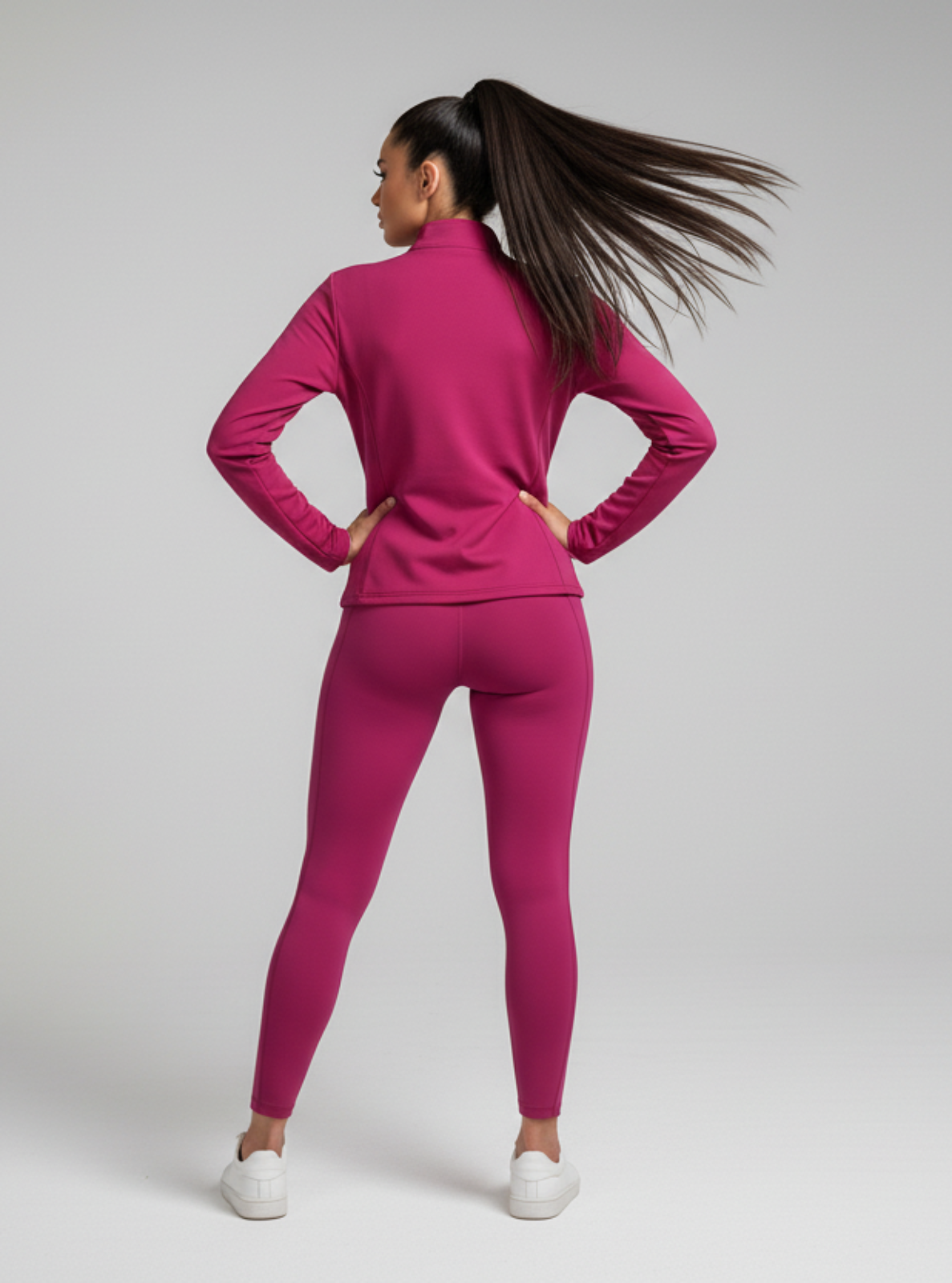 Woman wearing a pink tracksuit on a gray background