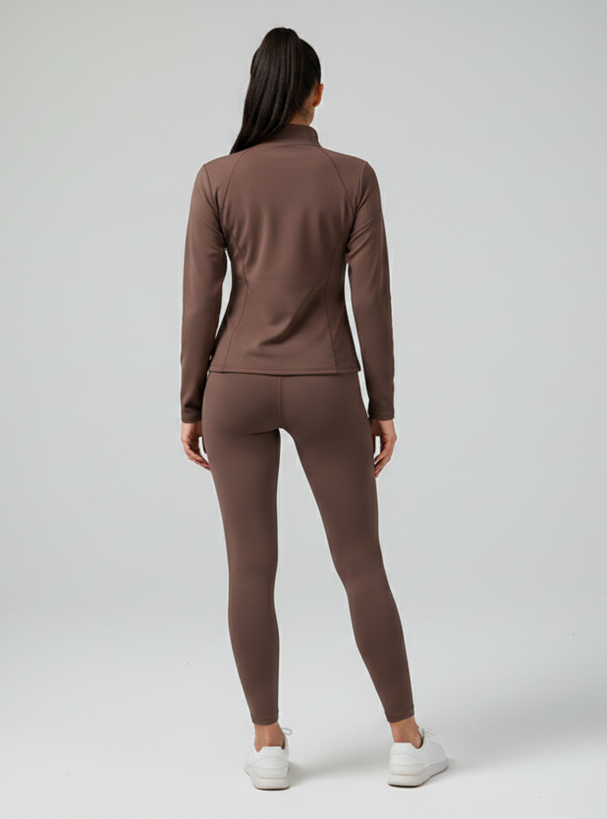 Person wearing a brown tracksuit on a white background