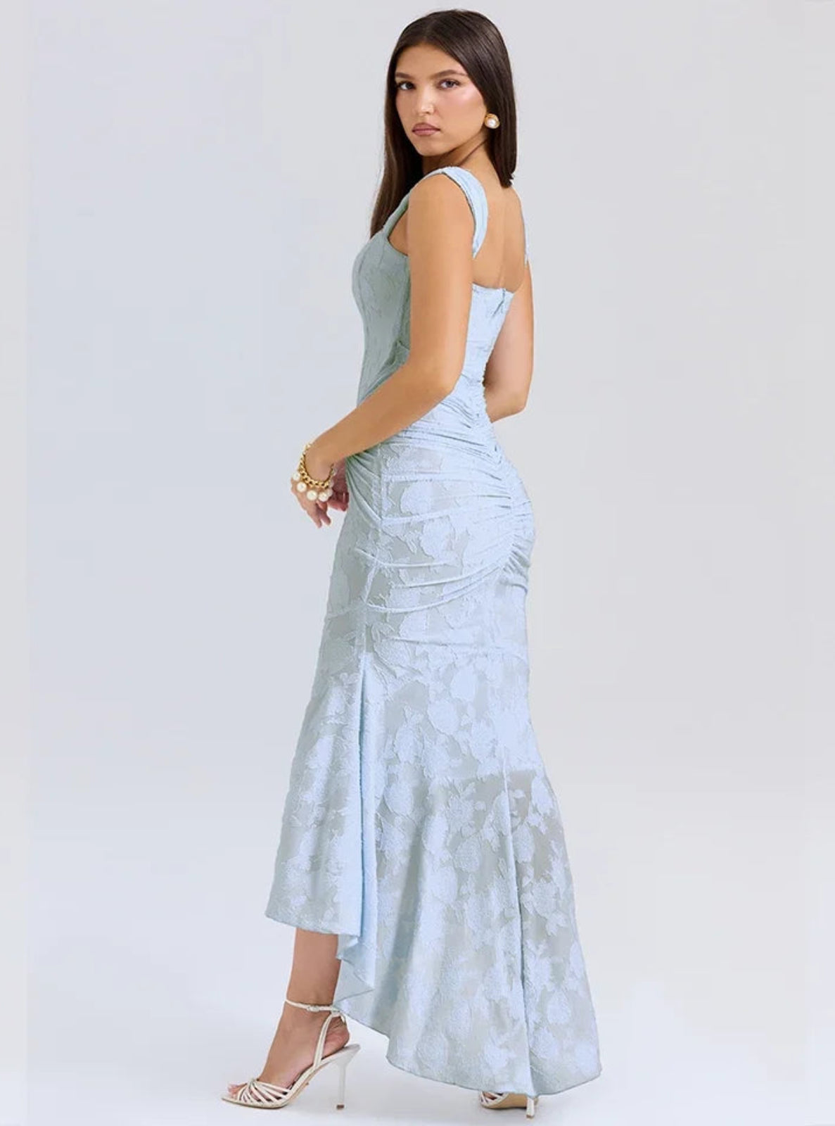Woman wearing a light blue lace dress on a white background