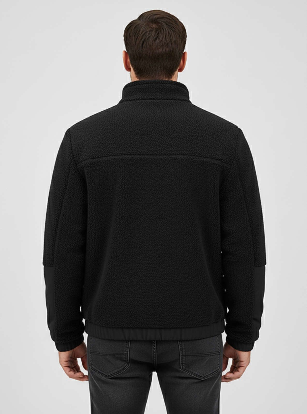 Man wearing a black jacket on a light gray background