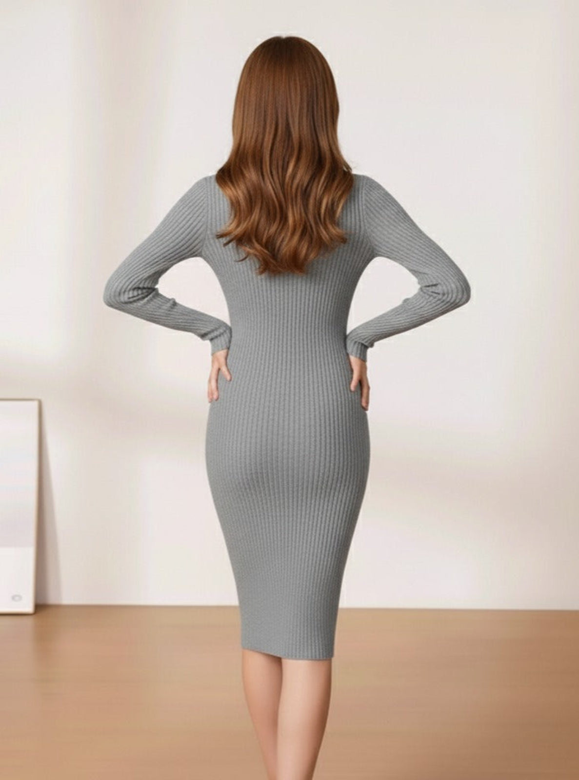 Woman wearing a gray ribbed dress with a plain background