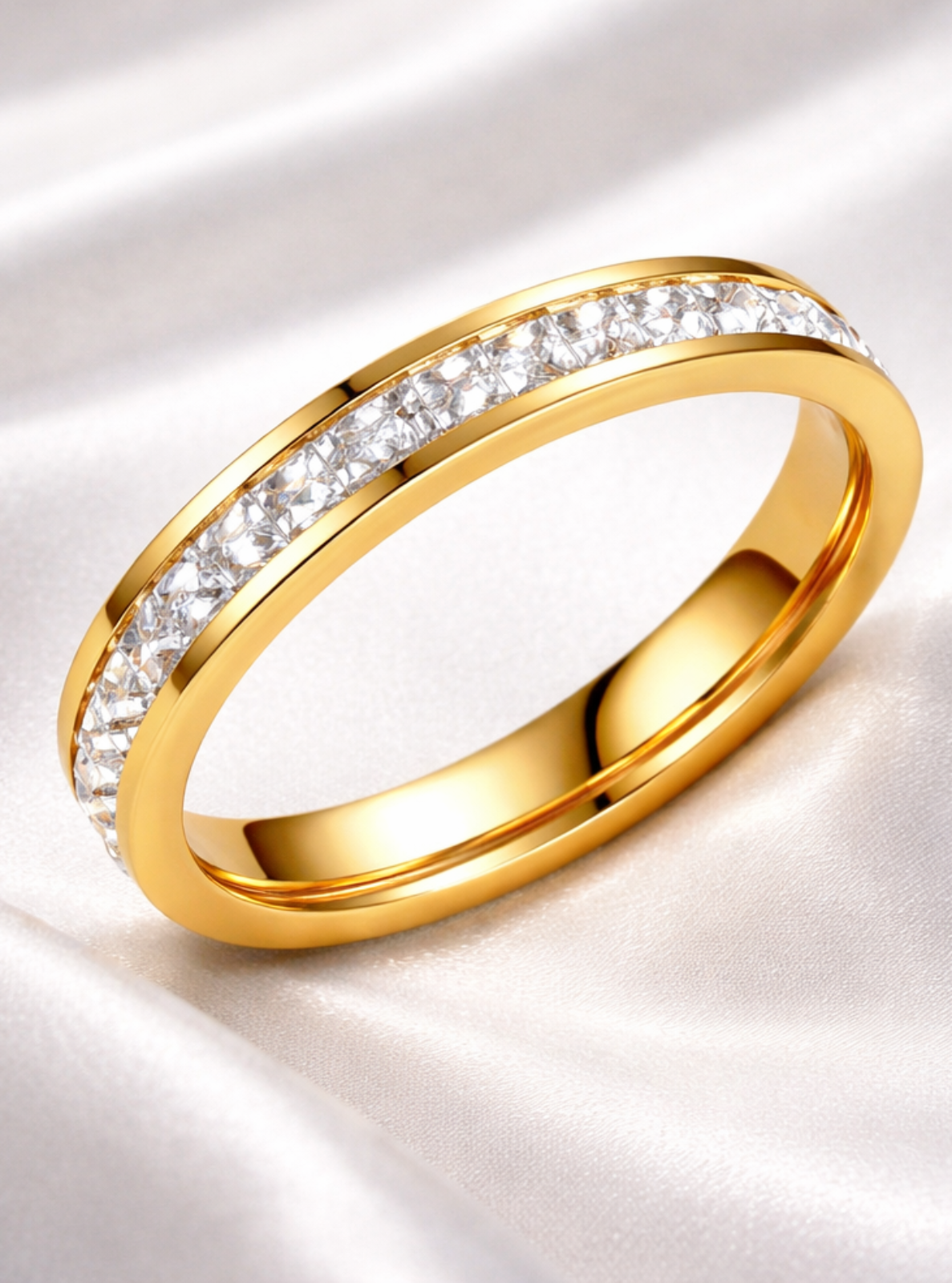 Gold ring with diamonds on a white fabric background