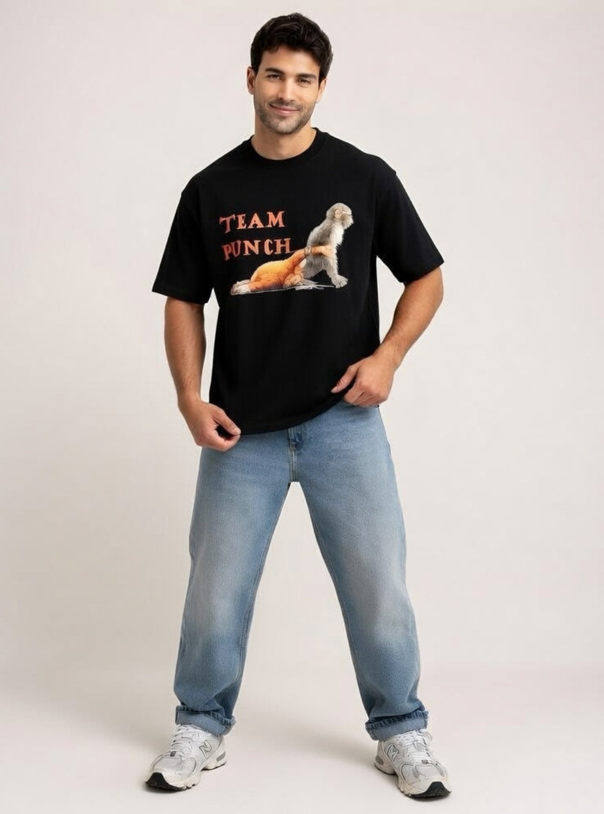 Man wearing a black t-shirt with 'Team Punch' graphic and light blue jeans on a plain background