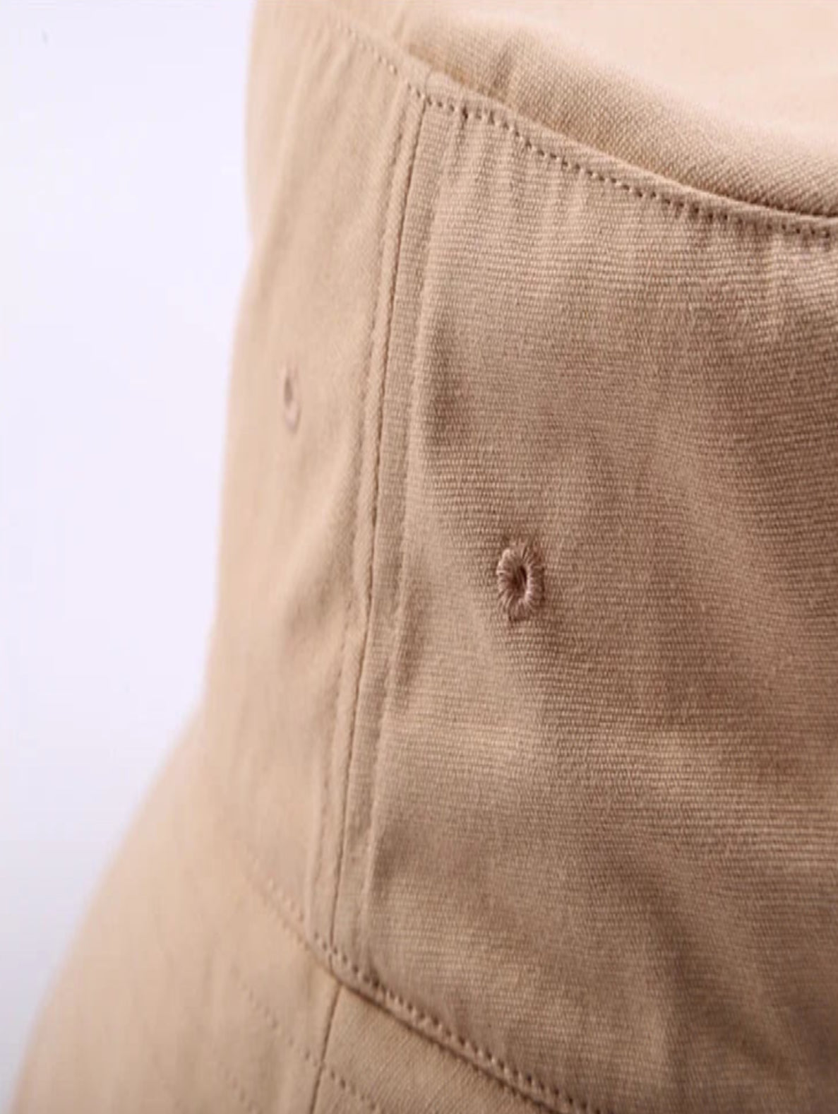 Close-up of a brown fabric surface with a small hole.