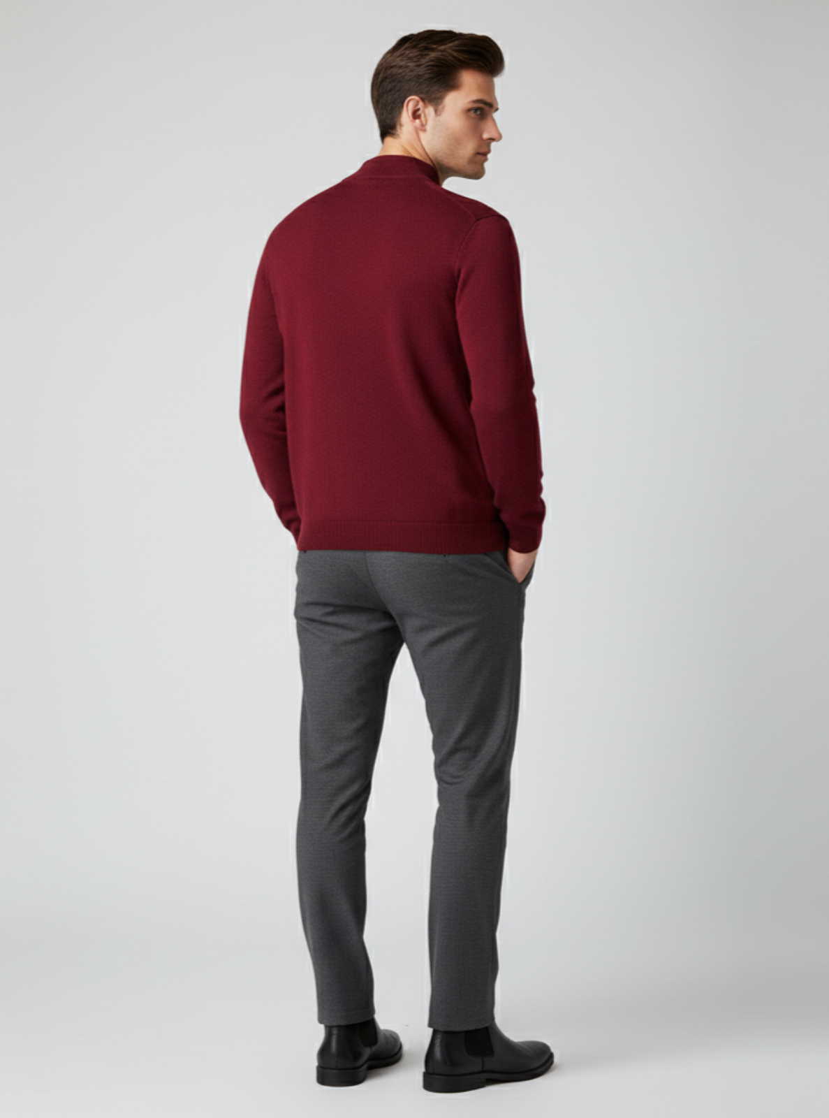 Man wearing a red sweater and gray pants on a white background