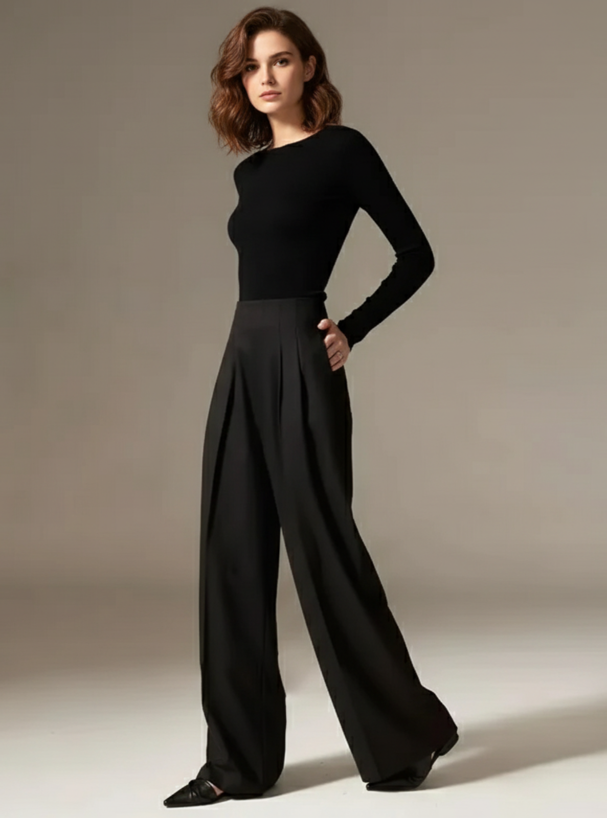 Woman wearing a black outfit against a neutral background