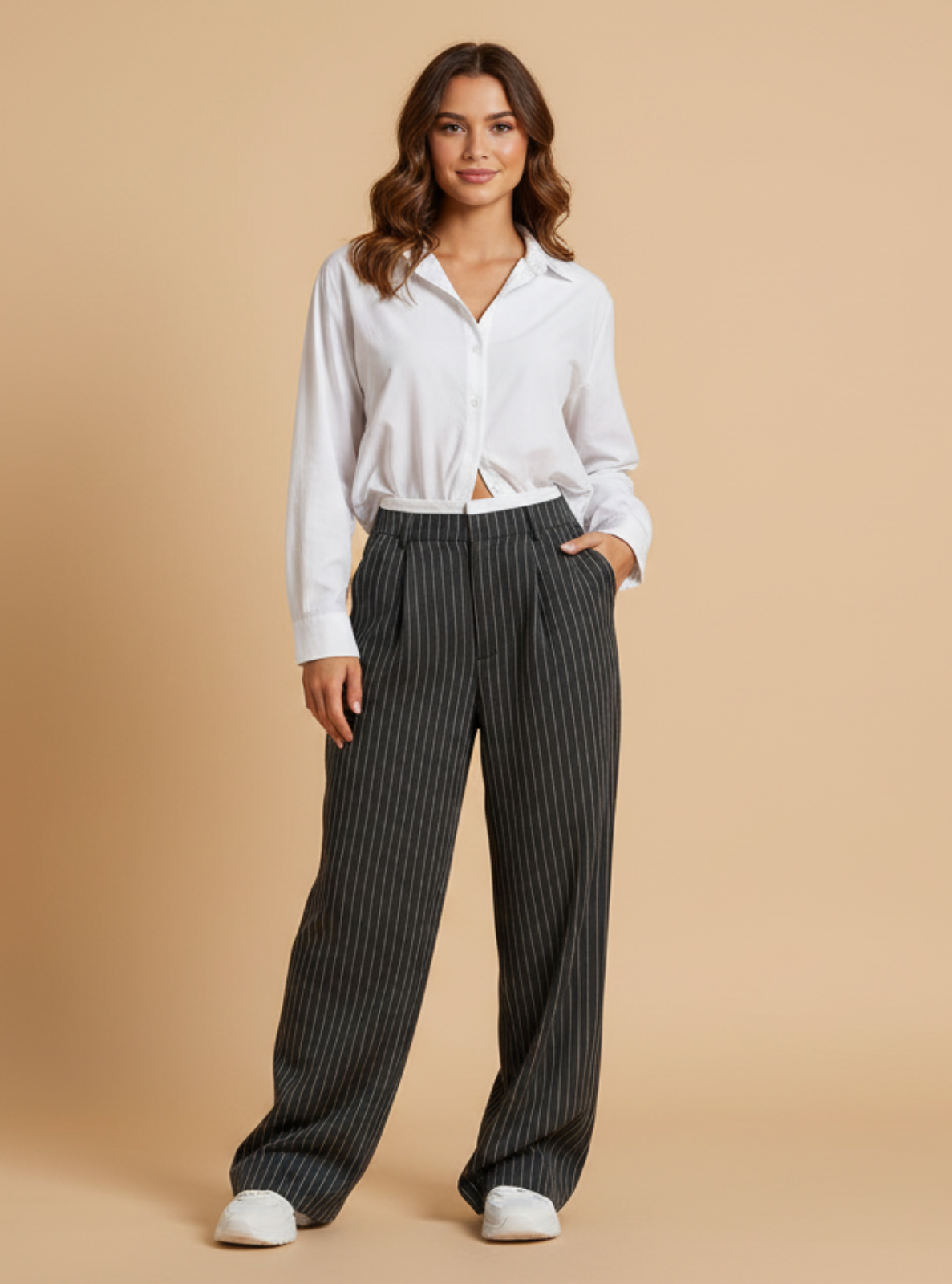 Woman wearing a white shirt and black pinstripe pants on a beige background