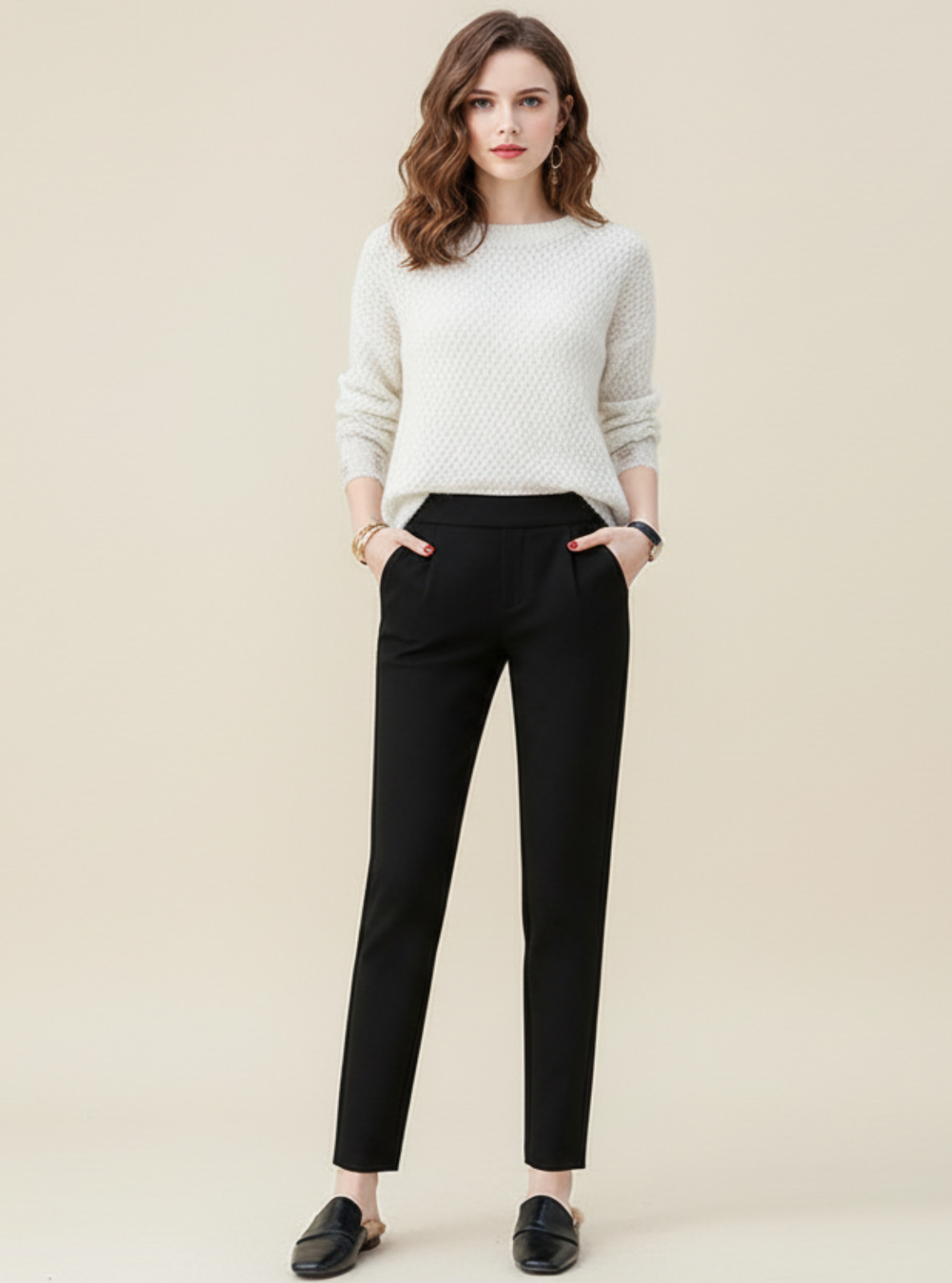 Woman wearing a white sweater and black pants on a beige background