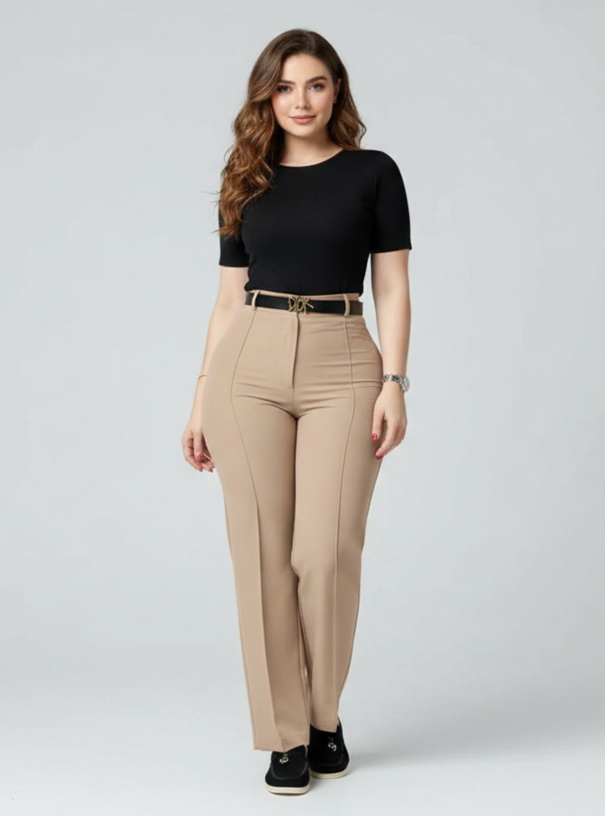 Woman wearing a black top and beige pants on a gray background