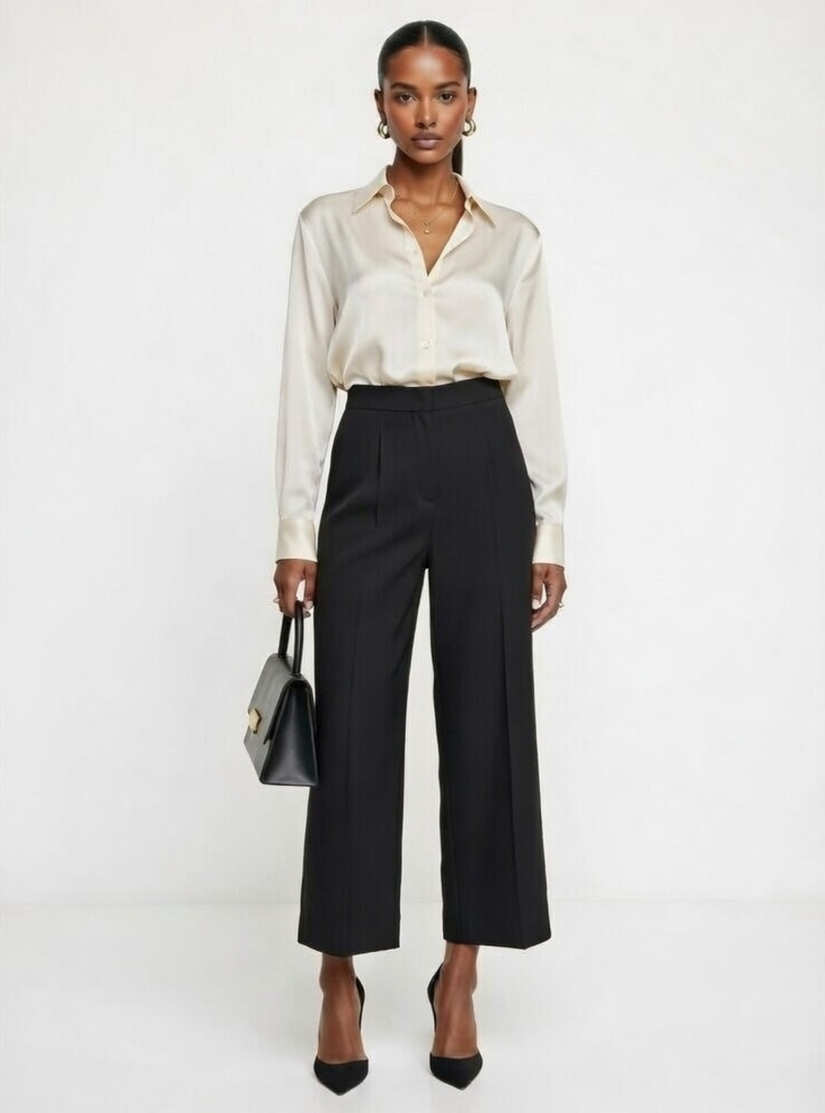 Woman wearing a white blouse and black pants on a white background