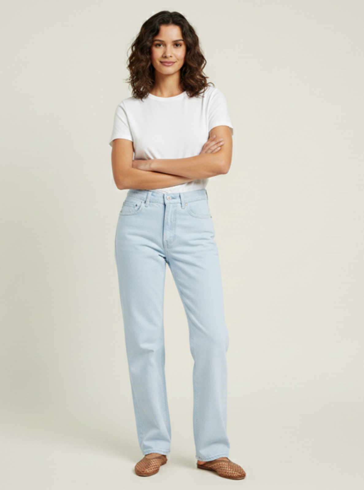 Person wearing light blue jeans and a white t-shirt on a plain background