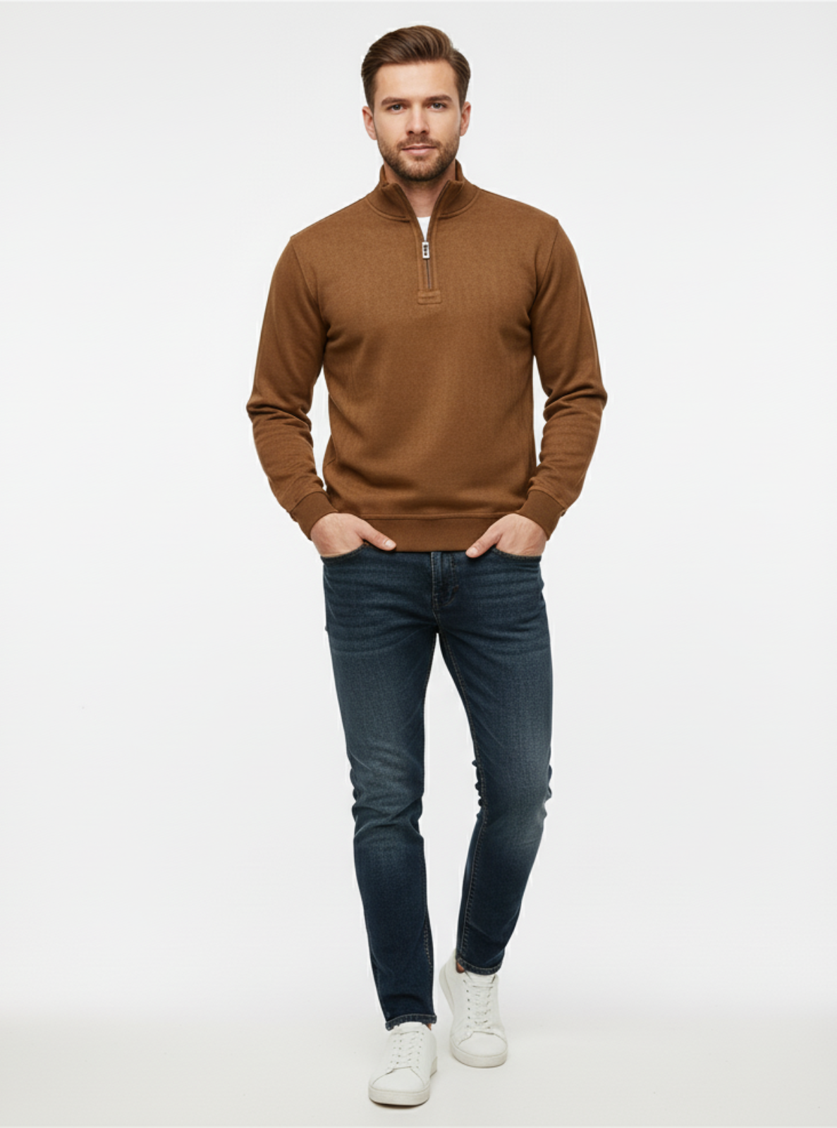 Man wearing a brown sweater and blue jeans on a white background