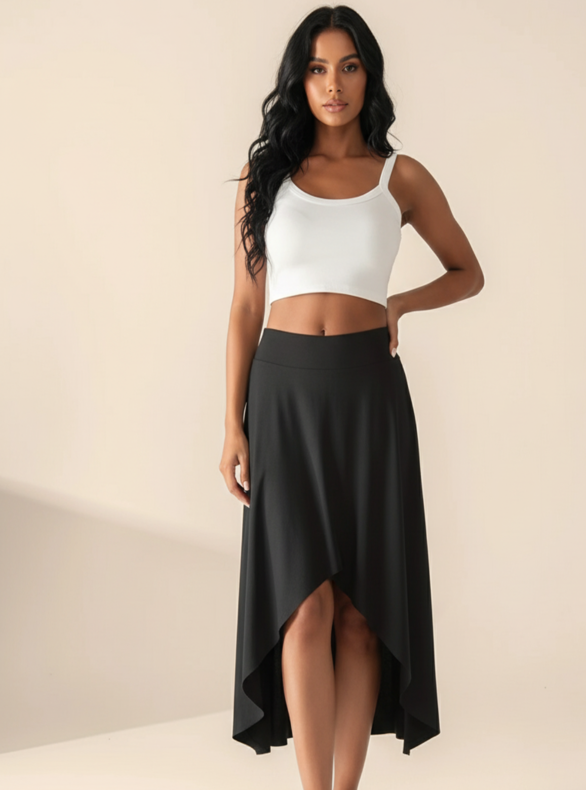 Woman wearing a white tank top and black skirt on a beige background