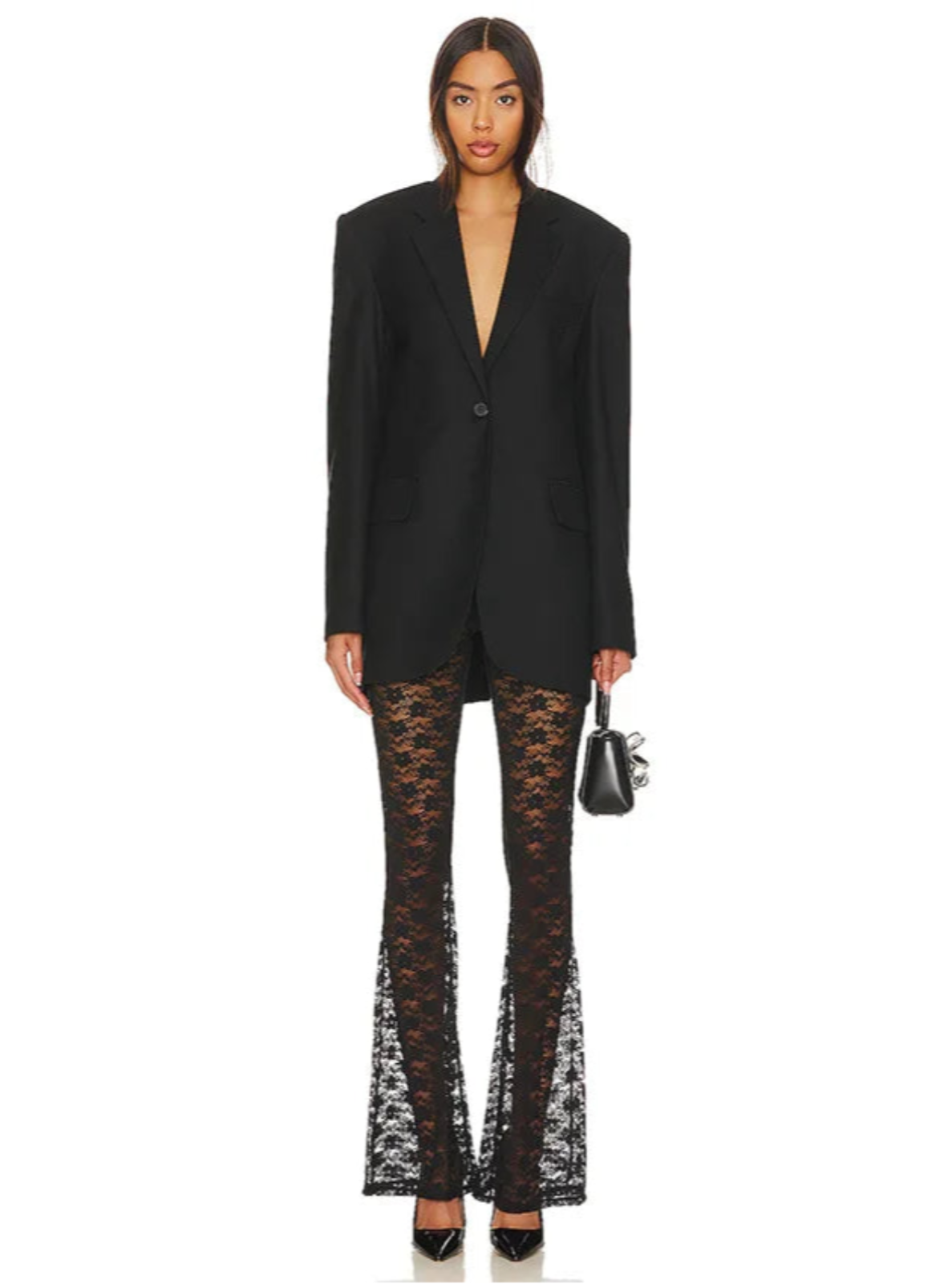 Woman wearing a black blazer and lace pants on a white background
