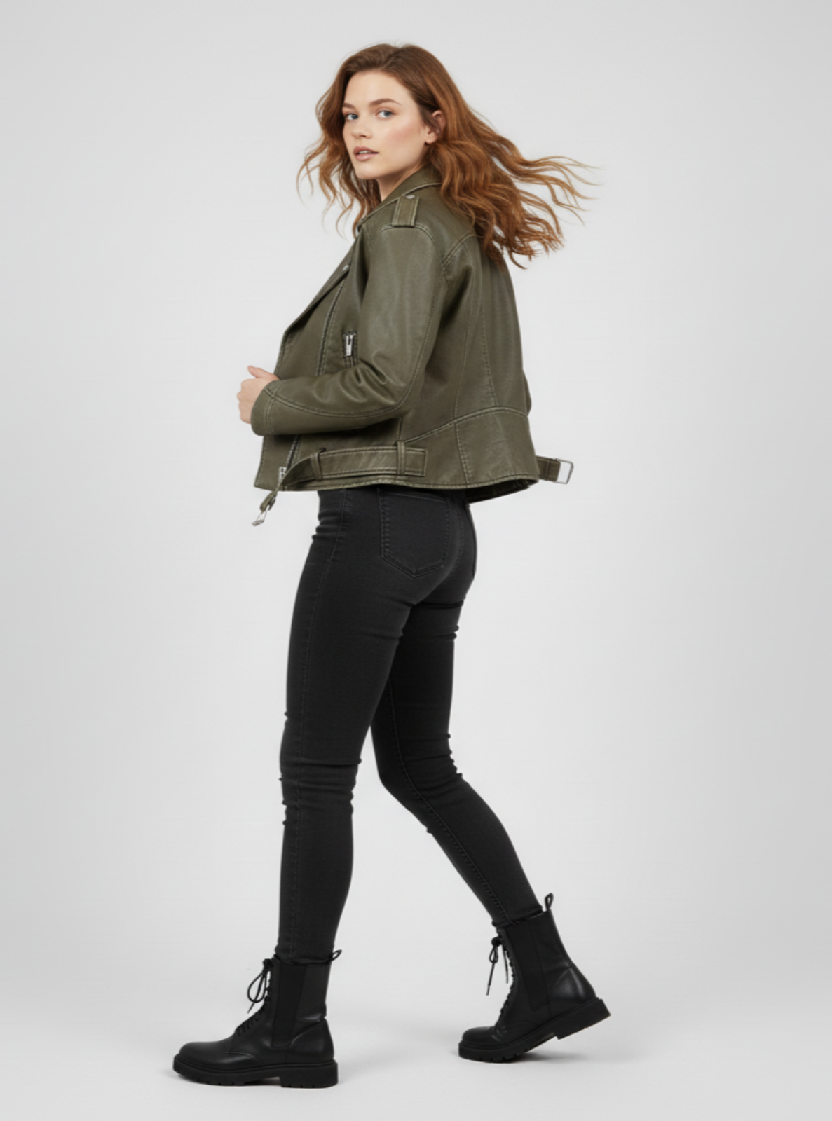 Woman wearing a green jacket, black pants, and black boots on a white background