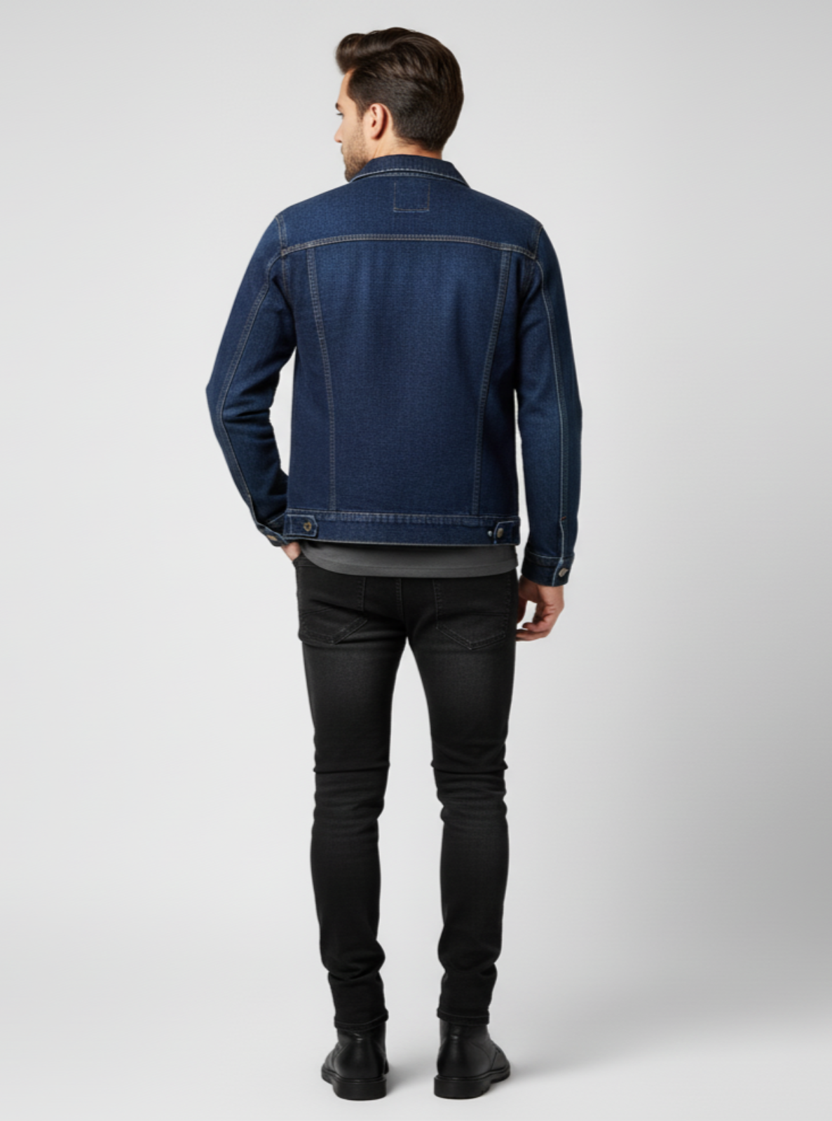 Man wearing a blue denim jacket and black pants on a white background