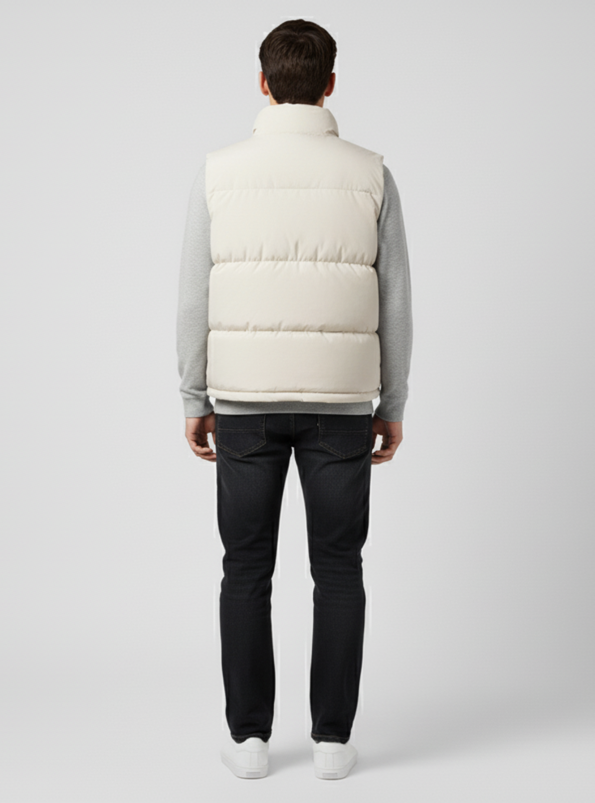 Man wearing a white puffer vest on a light gray background