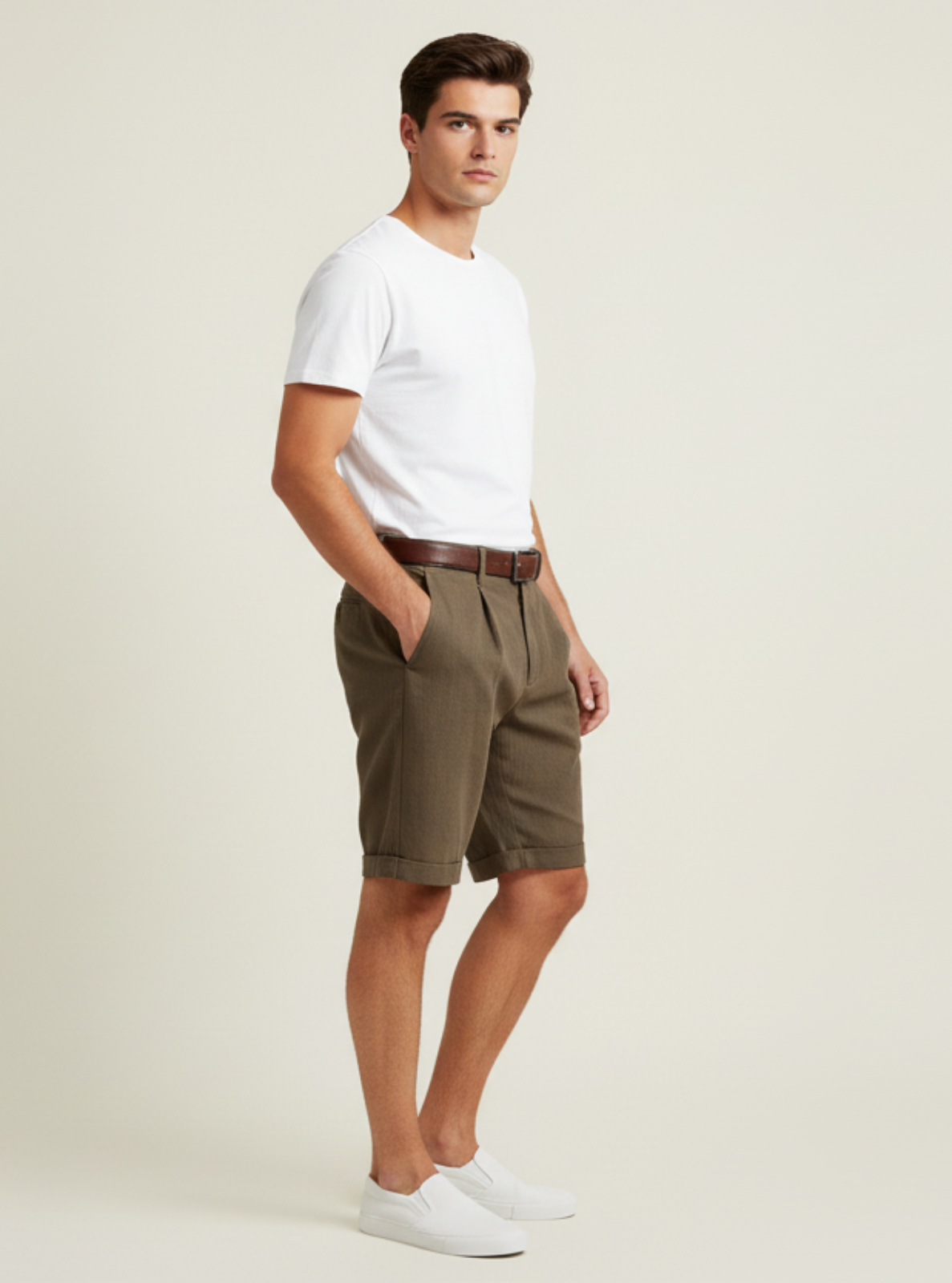 Man wearing a white t-shirt and green shorts on a plain background