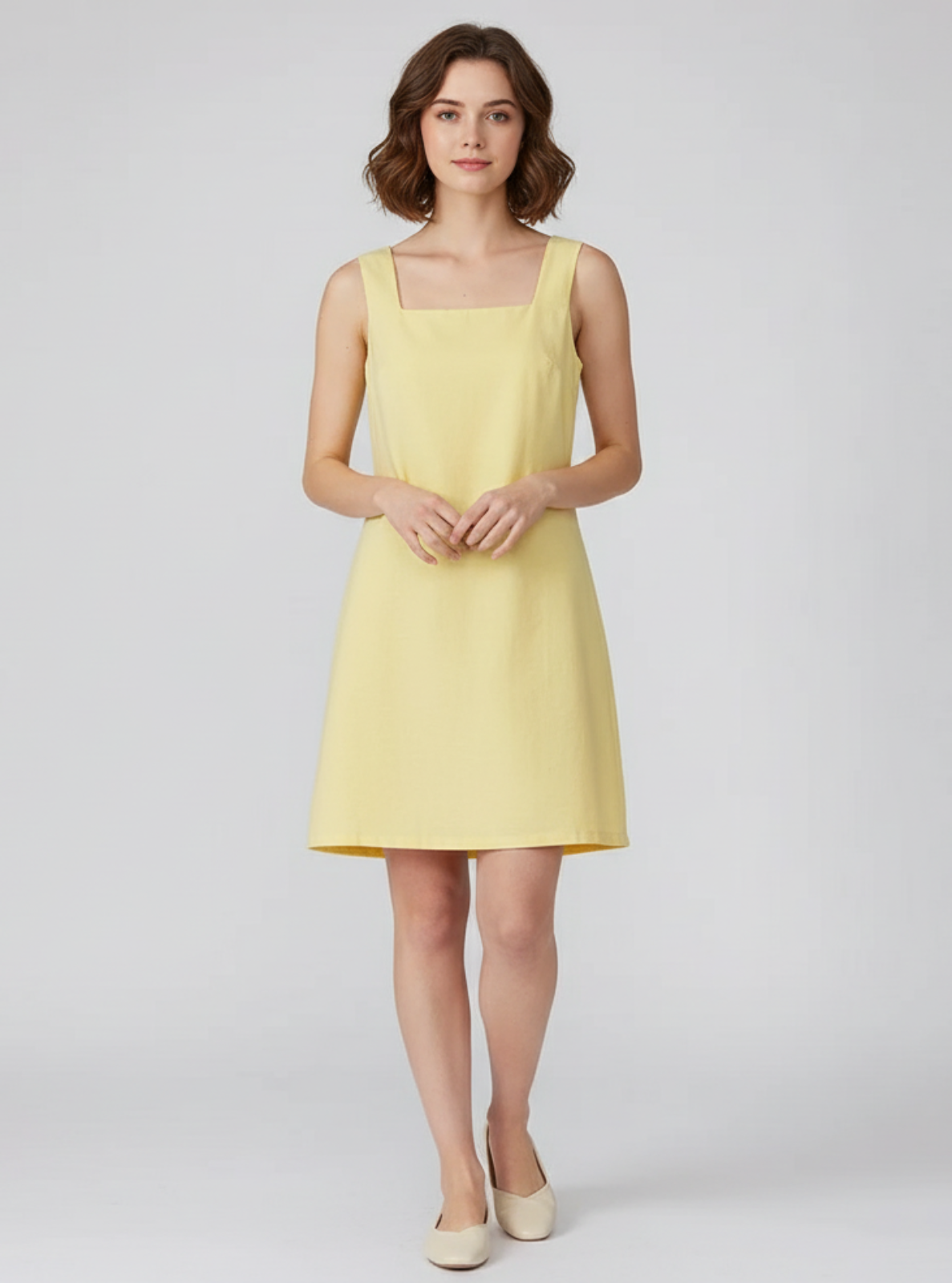 Woman wearing a yellow dress on a white background