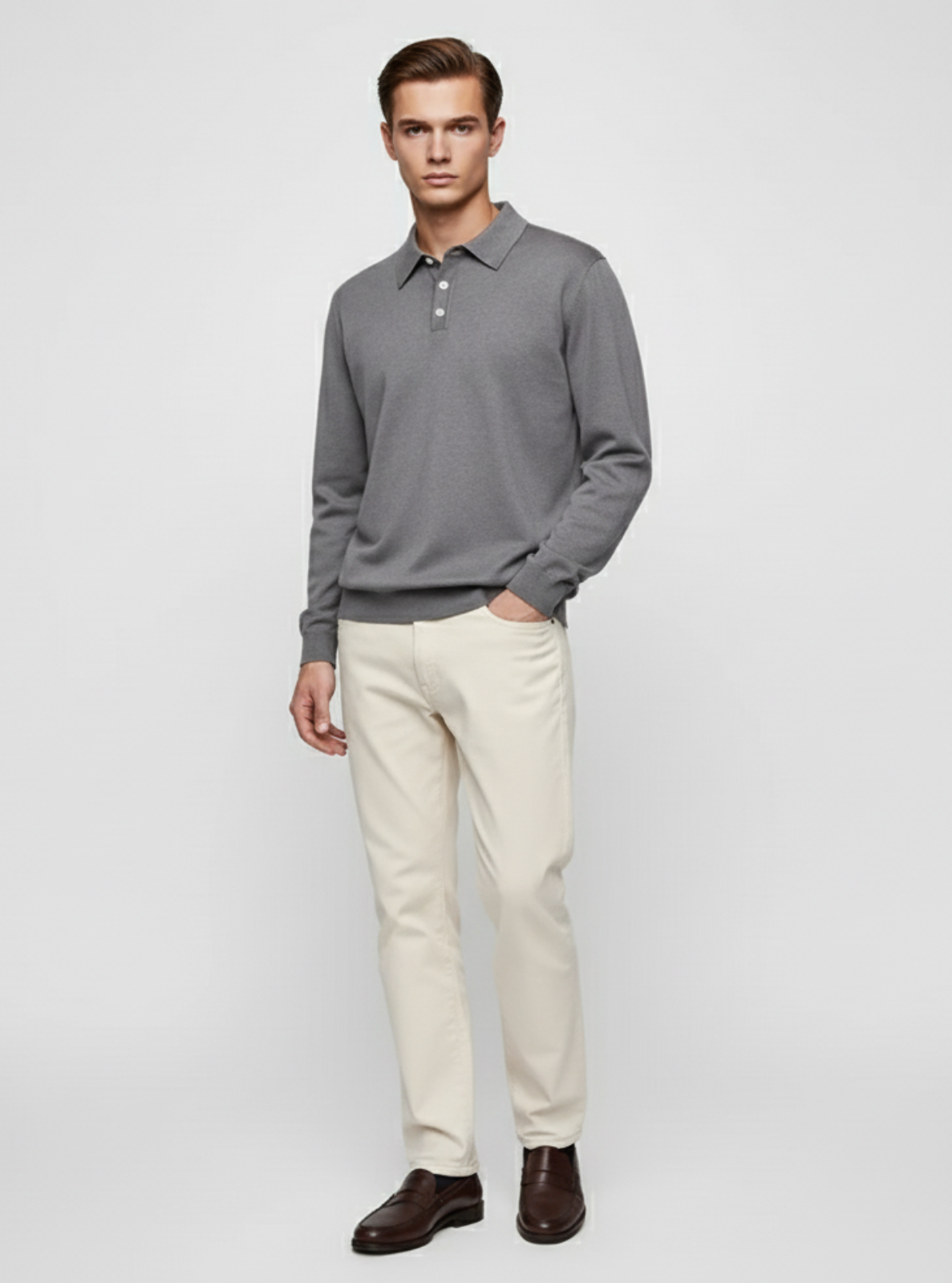 Man wearing a gray long-sleeve shirt and white pants on a light gray background