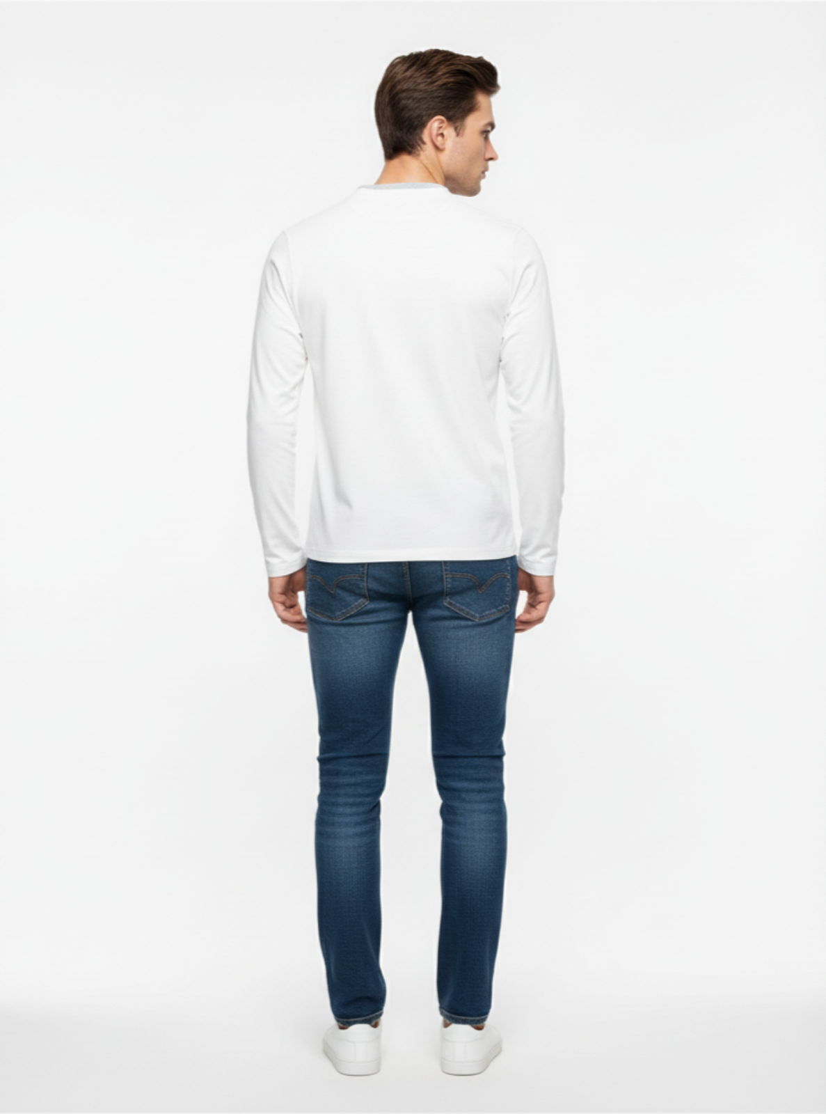 Man wearing a white long-sleeve shirt and blue jeans on a white background
