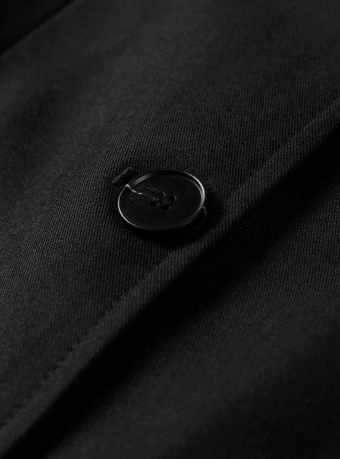 Close-up of a black button on a black fabric surface