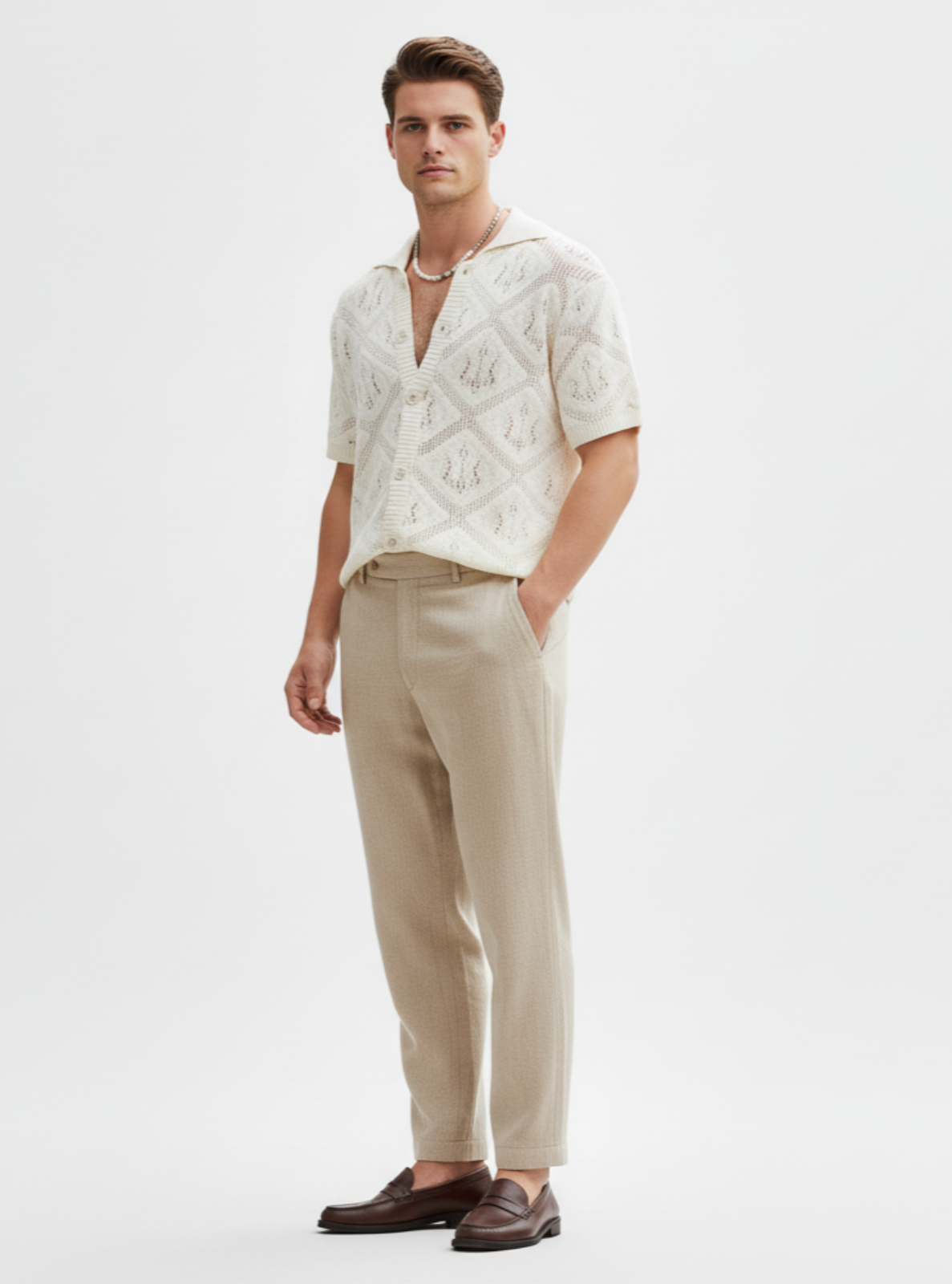 Man wearing a white patterned shirt and beige pants on a white background