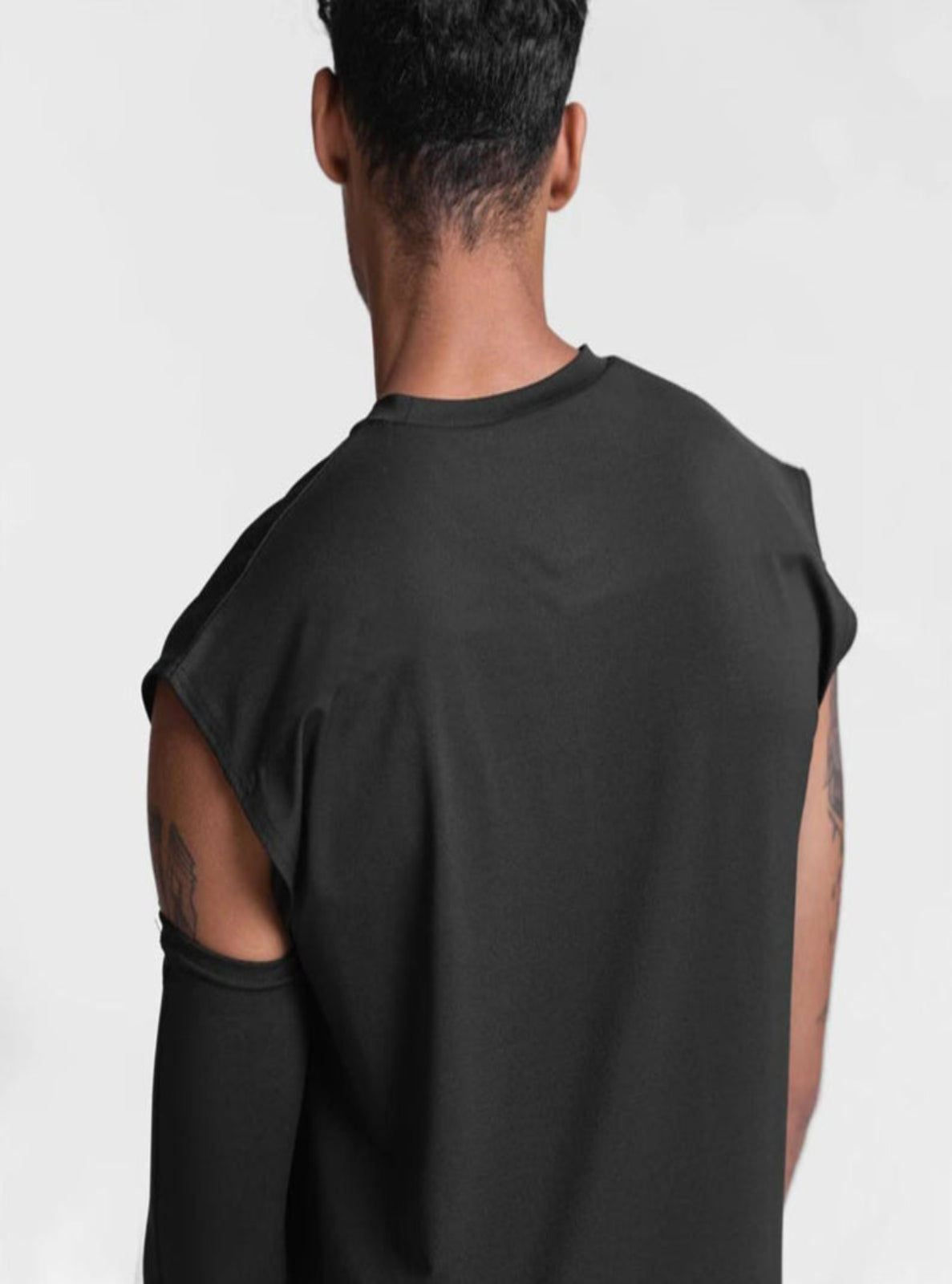 Person wearing a black sleeveless shirt on a white background