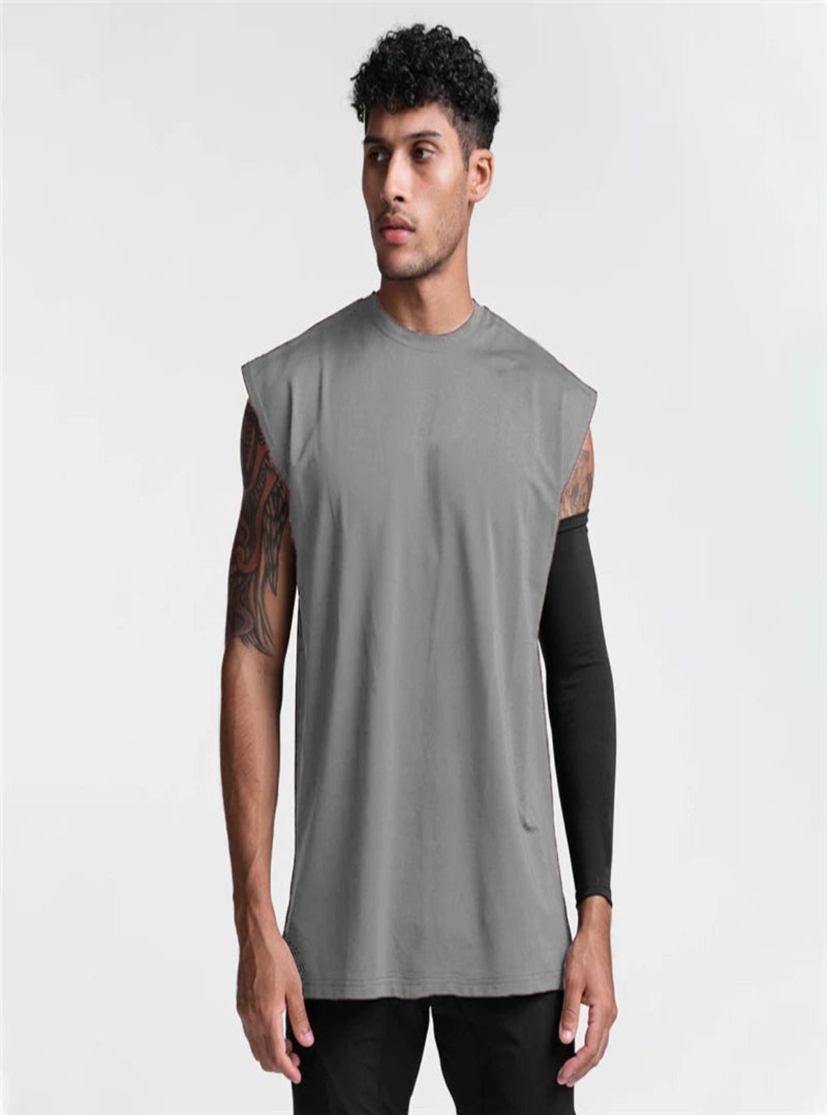Man wearing a sleeveless gray shirt with black sleeves on a white background