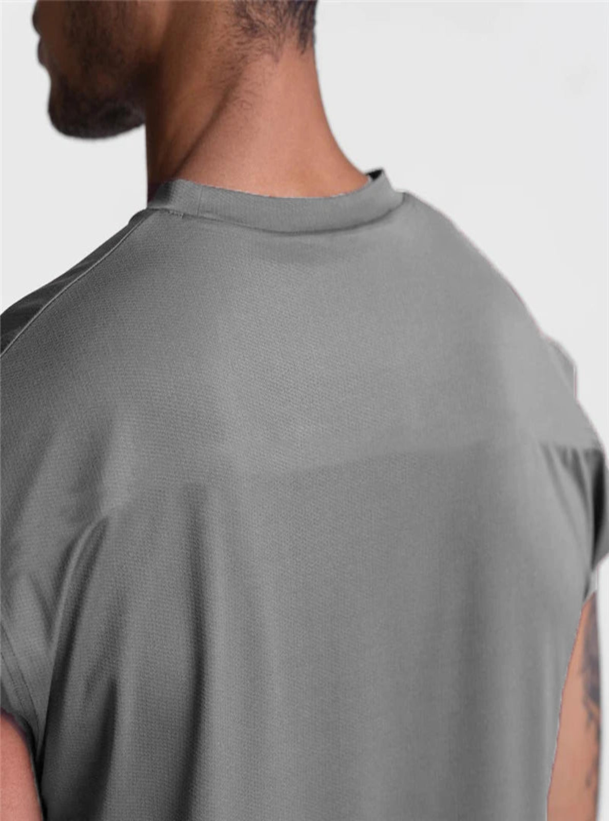 Gray sleeveless shirt worn by a person on a light gray background