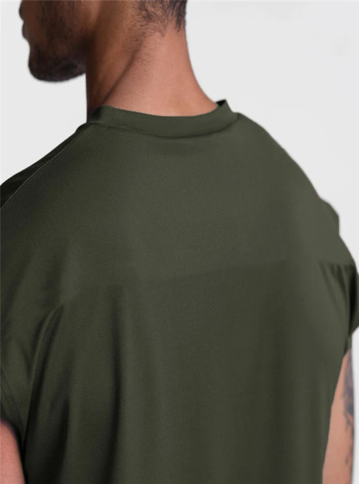 Person wearing a green sleeveless shirt on a white background