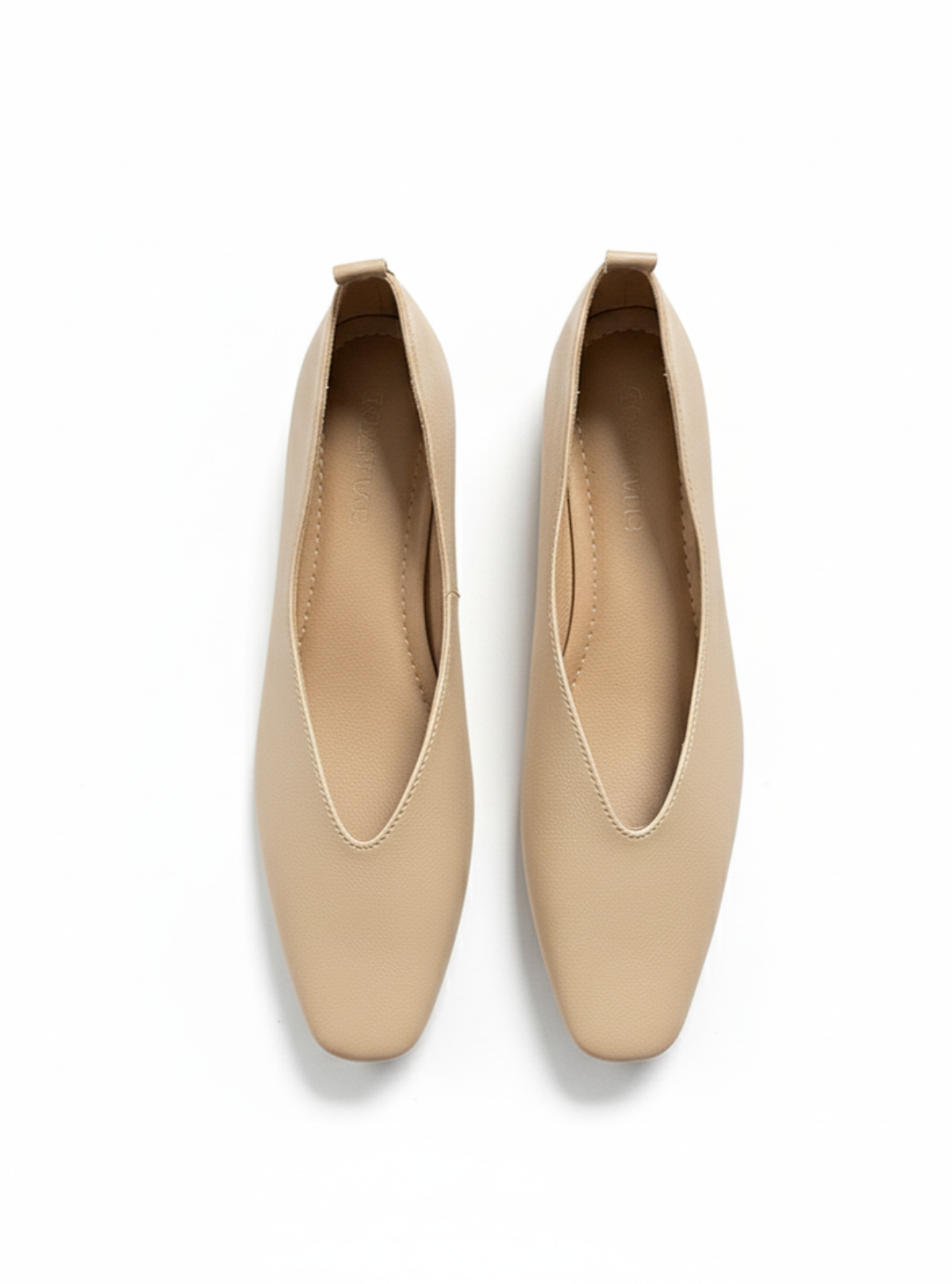 Pair of beige flat shoes on a white background