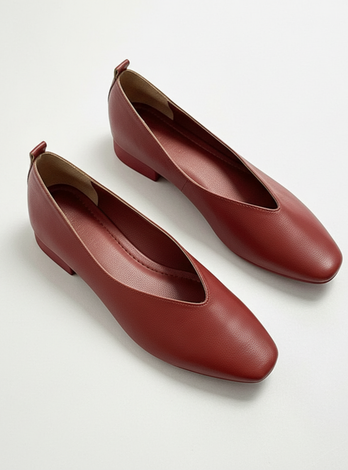 Pair of brown leather shoes on a light gray background