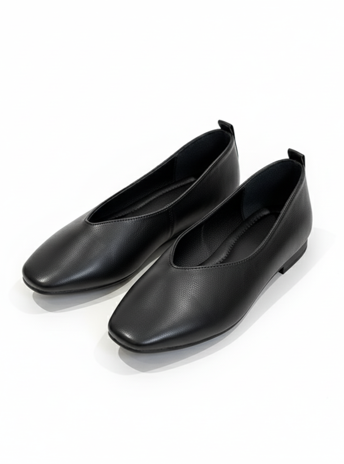 Pair of black leather loafers on a white background