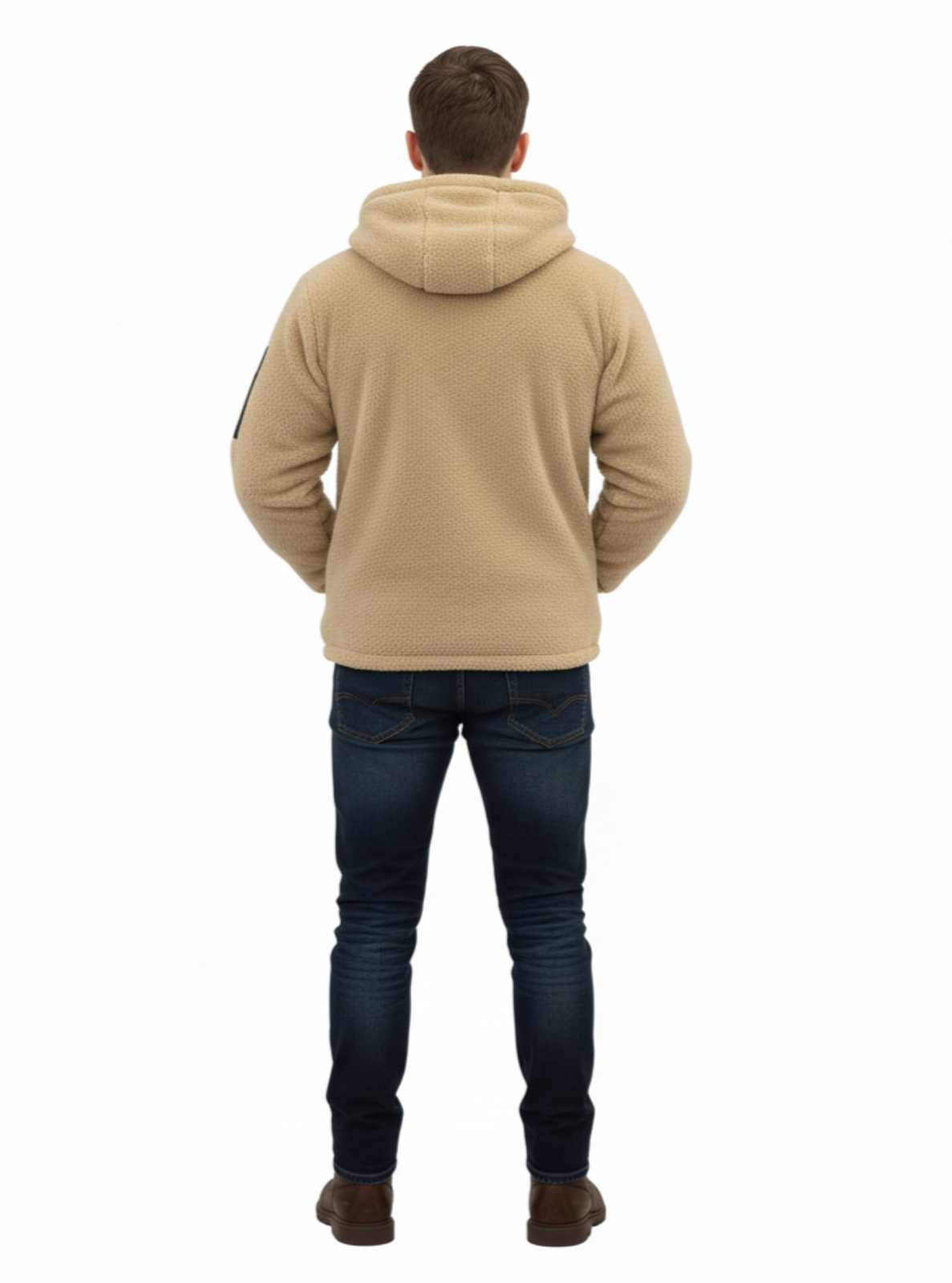 Person wearing a beige hoodie and dark jeans on a white background